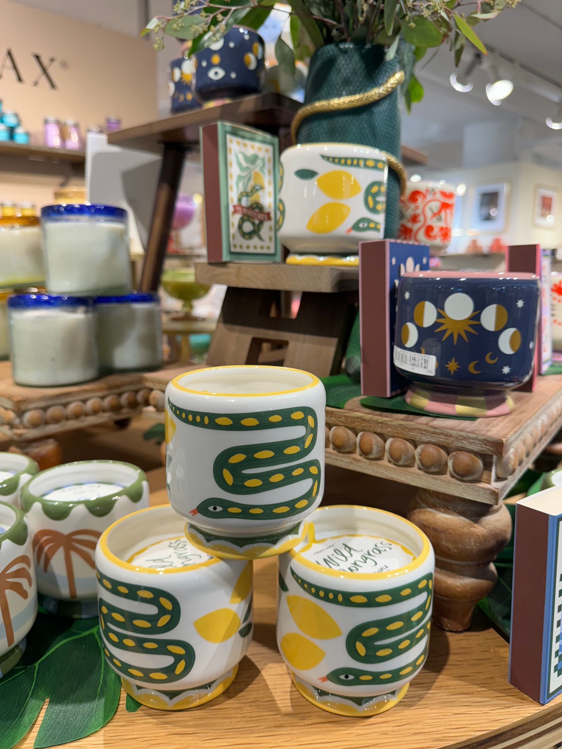 A display of candles and cups with a snake design on them