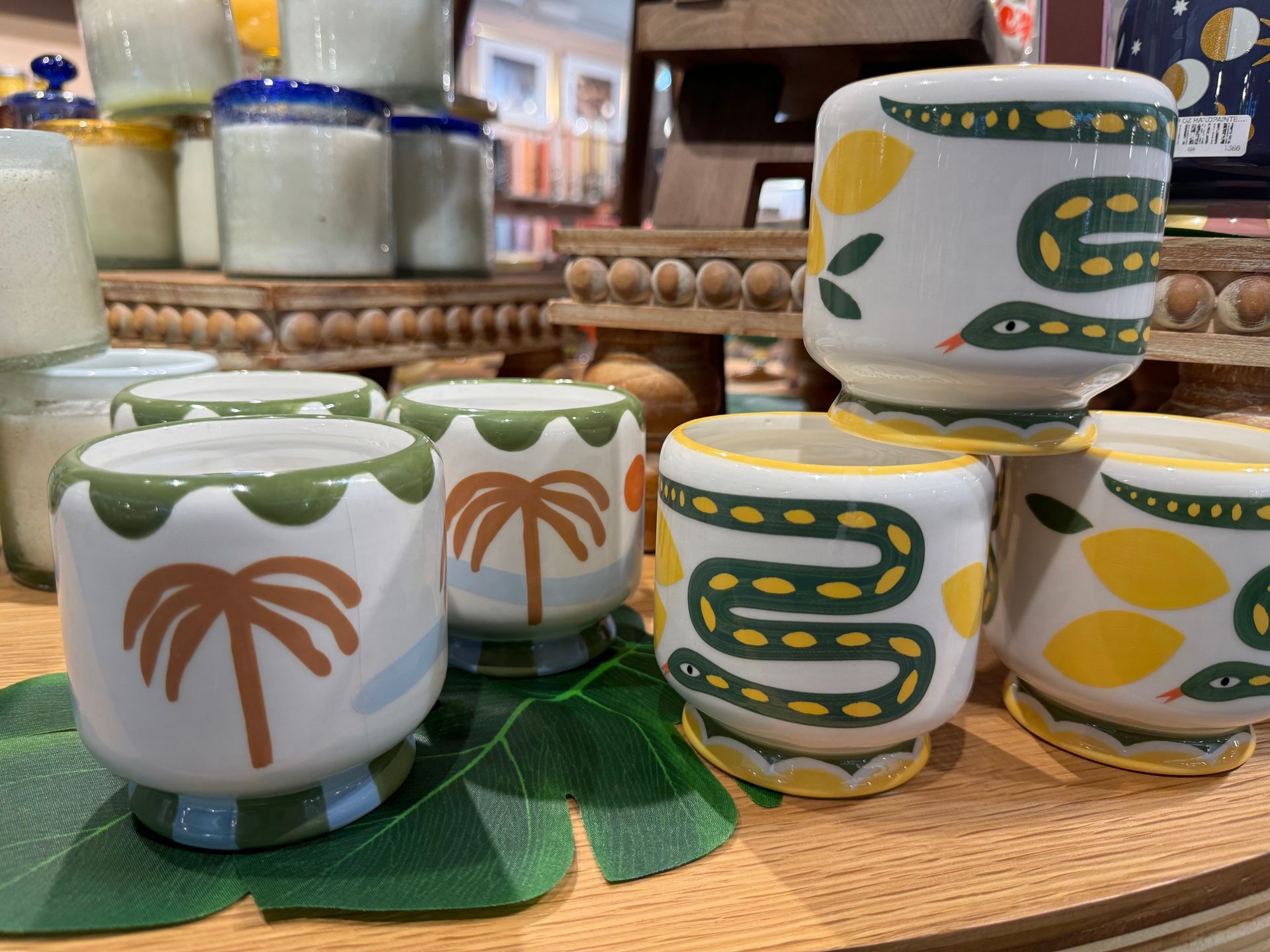 A display of cups with palm trees and snakes on them
