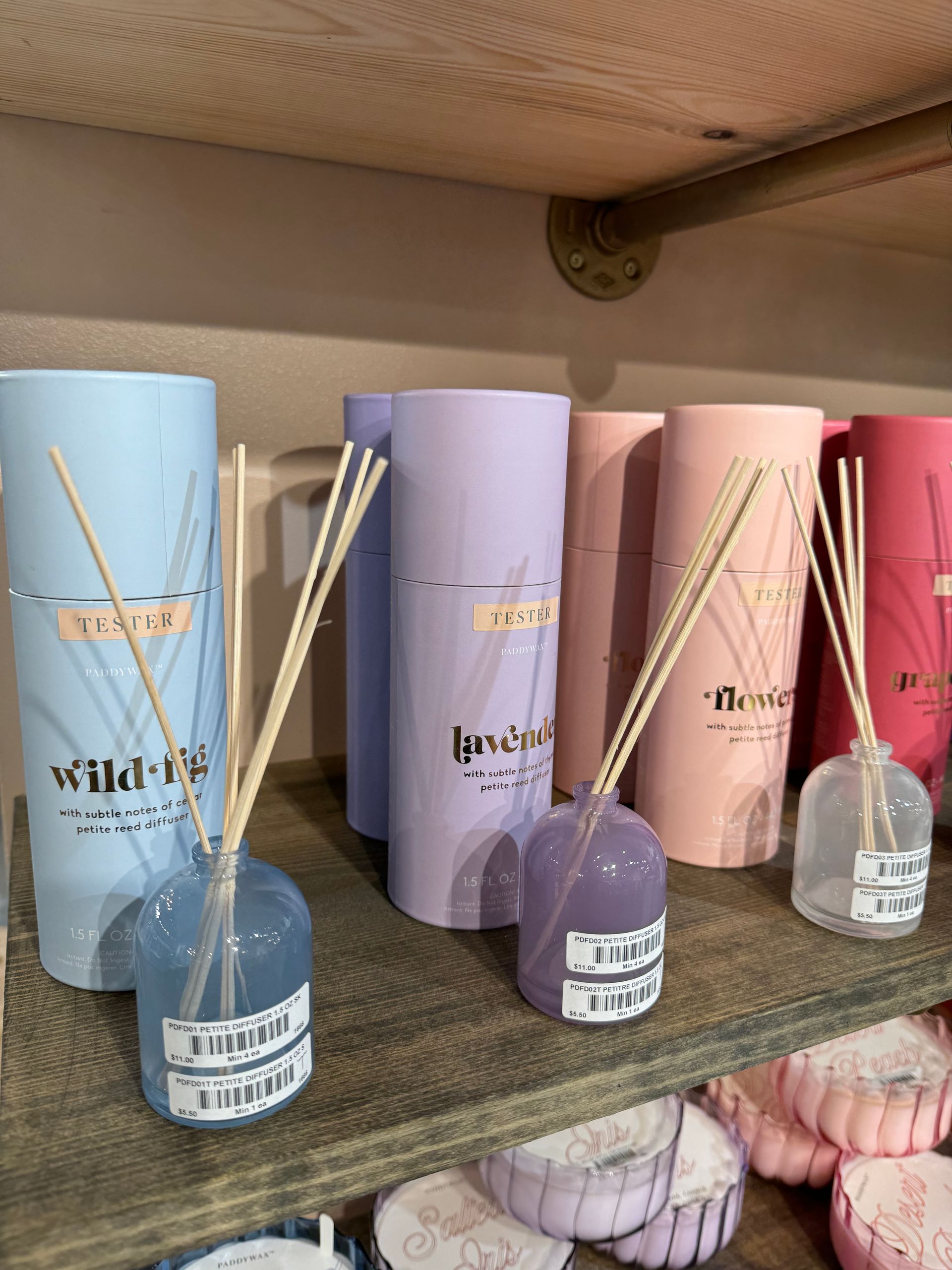 A row of reed diffusers are lined up on a shelf