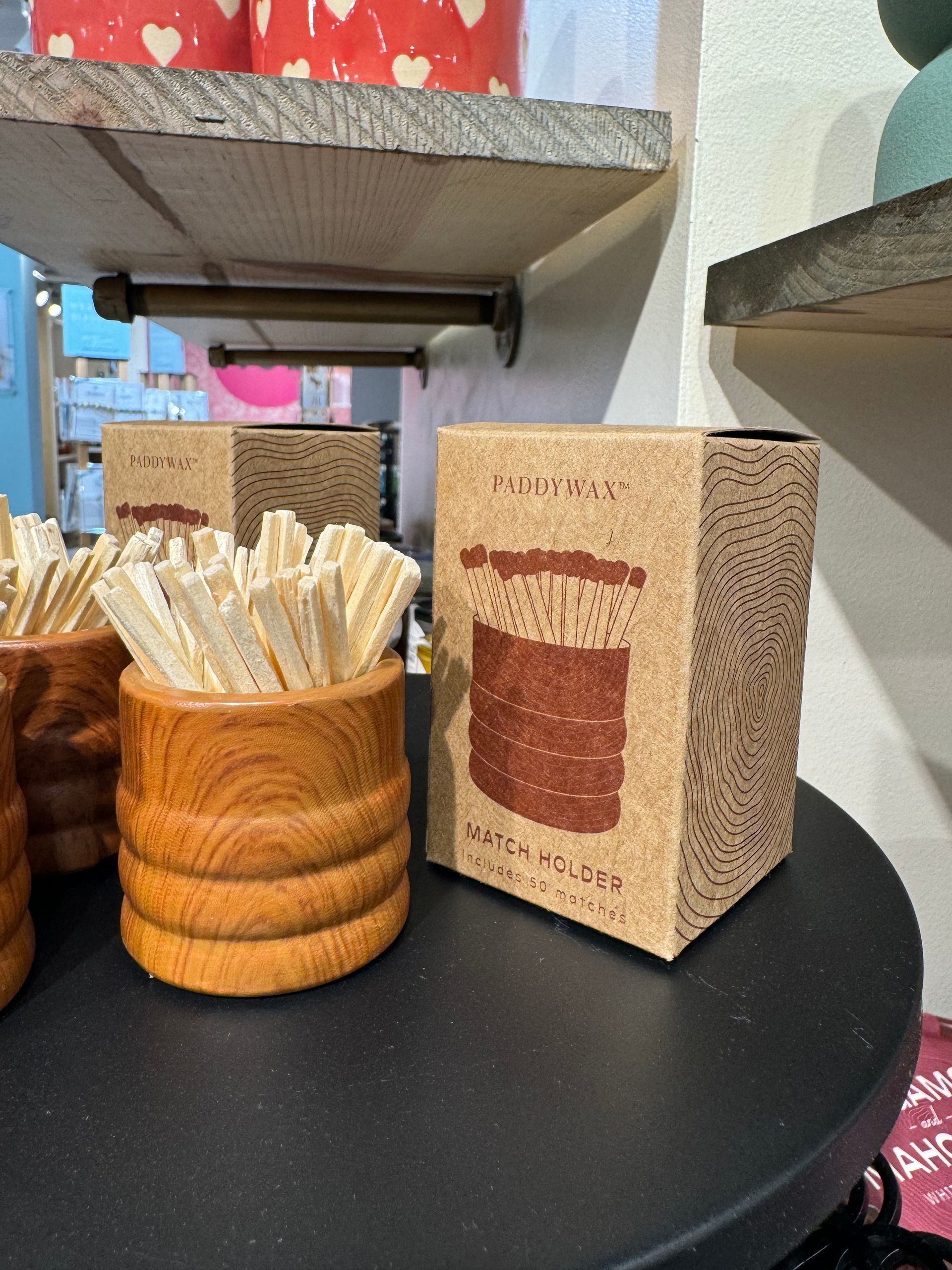 A wooden cup filled with toothpicks next to a box that says ' toothpicks ' on it