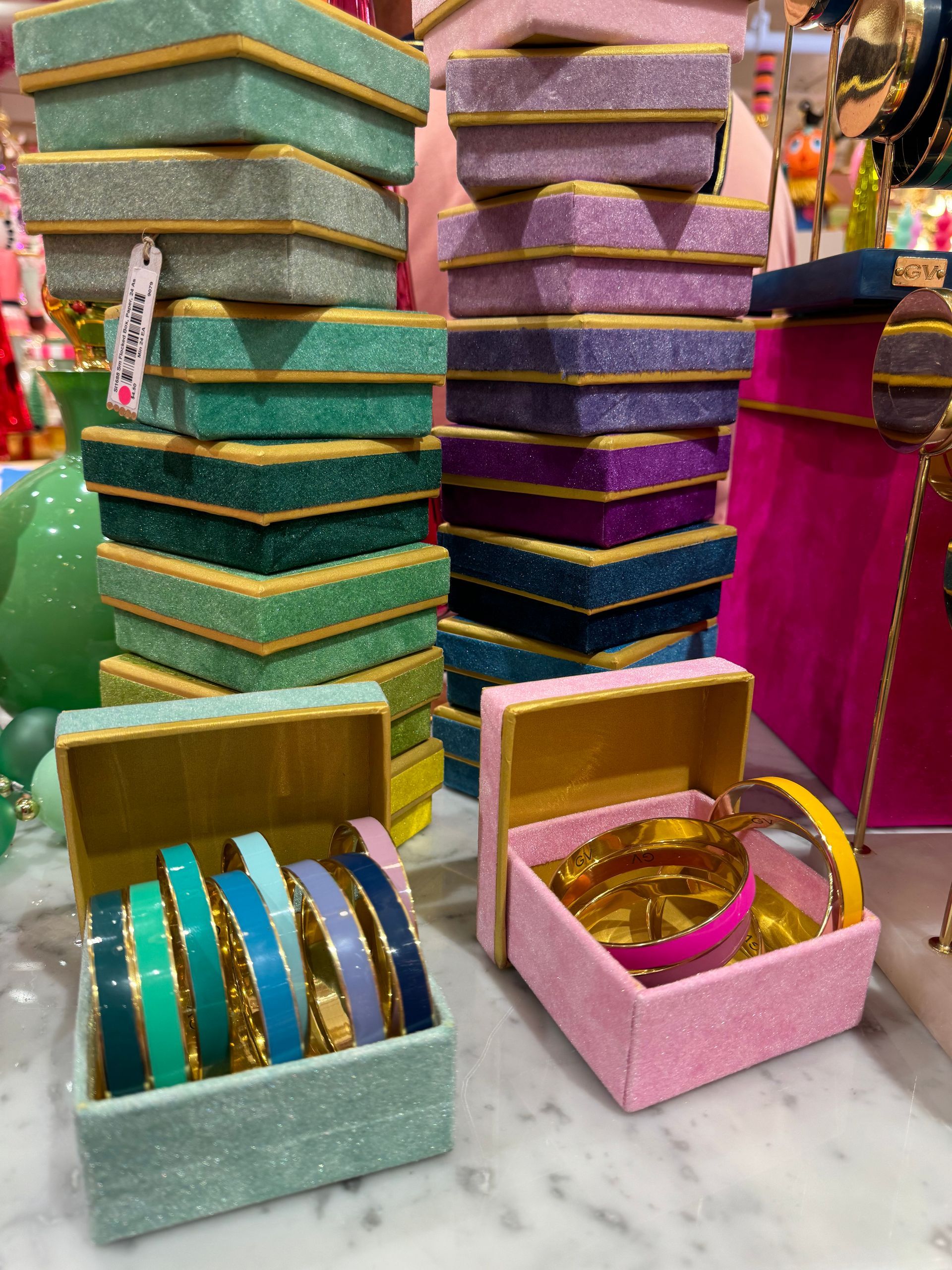 A stack of colorful boxes with bracelets in them