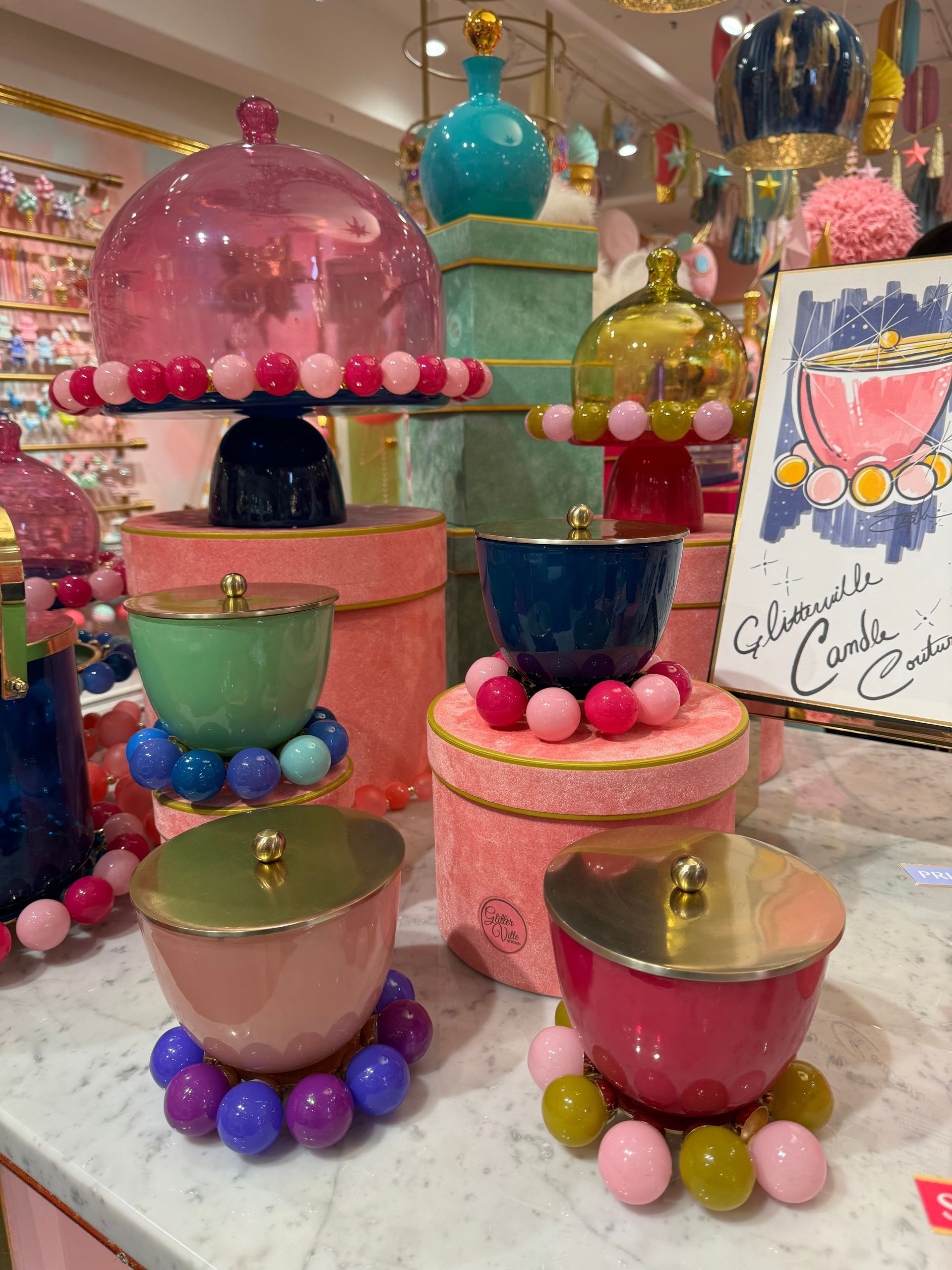 A display of colorful bowls and boxes with a sign that says ' glamour ' on it