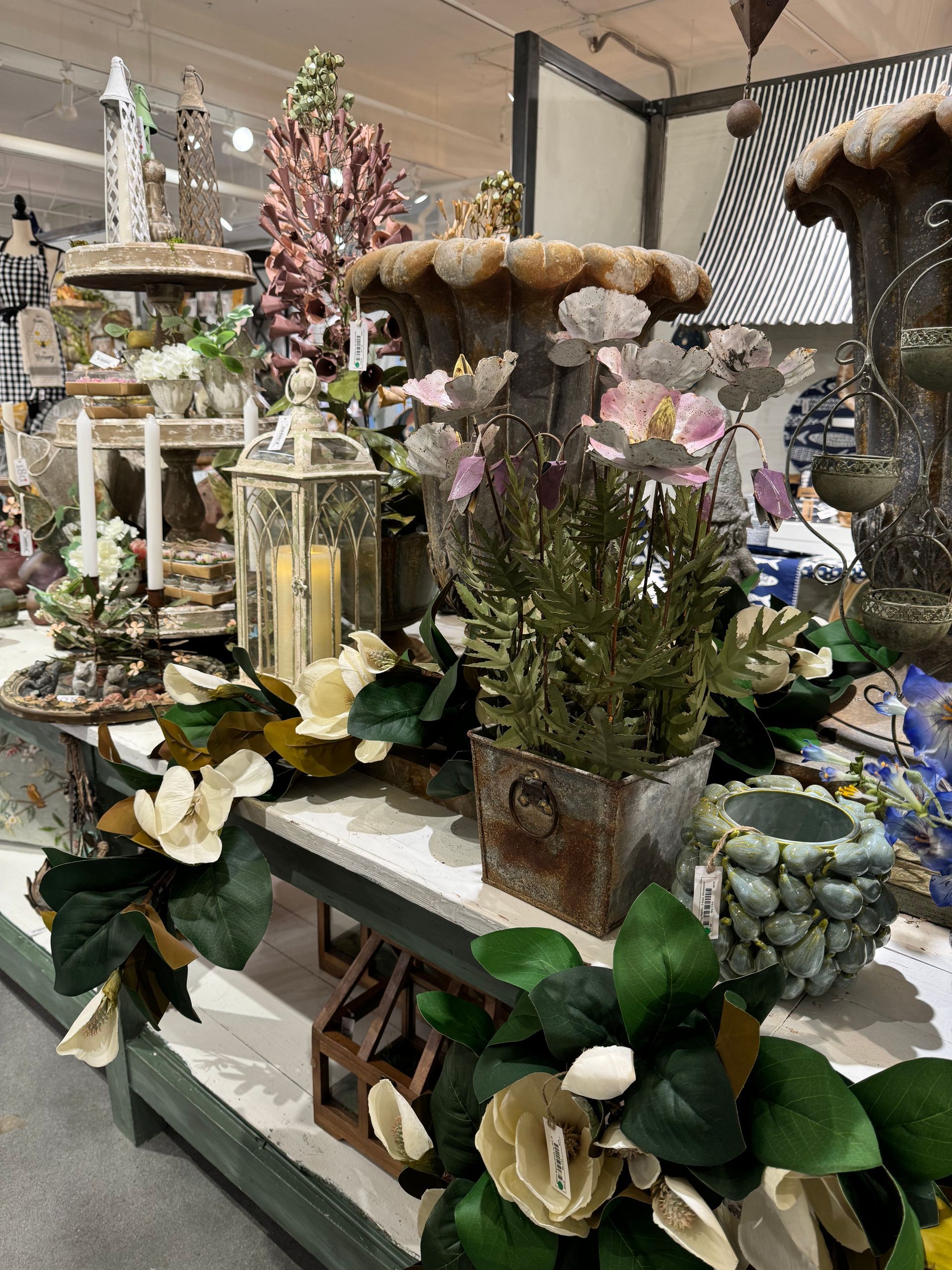 A display of flowers and candles in a store