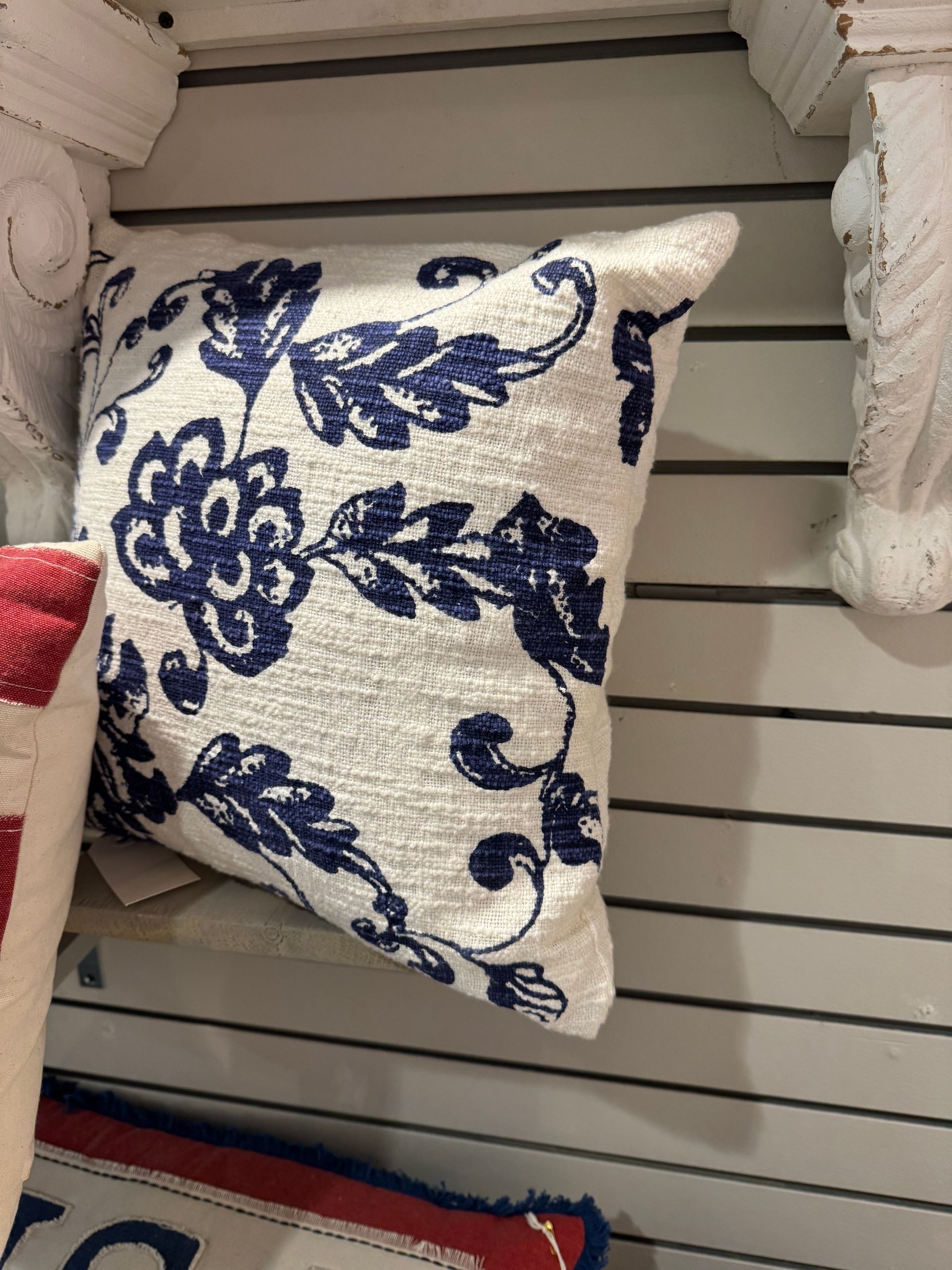 A white pillow with blue flowers on it