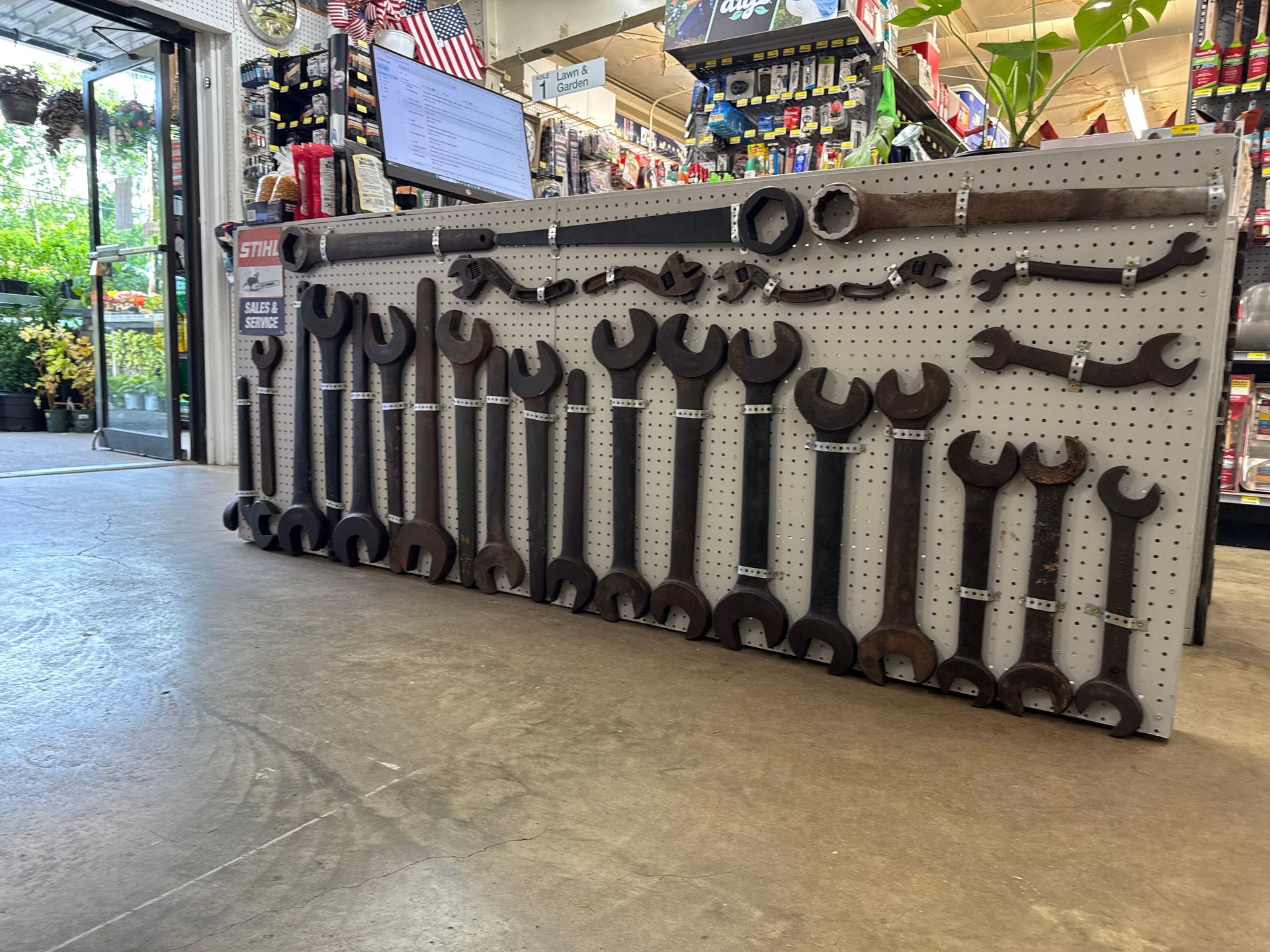 Display of large wrenches on a pegboard in a store.