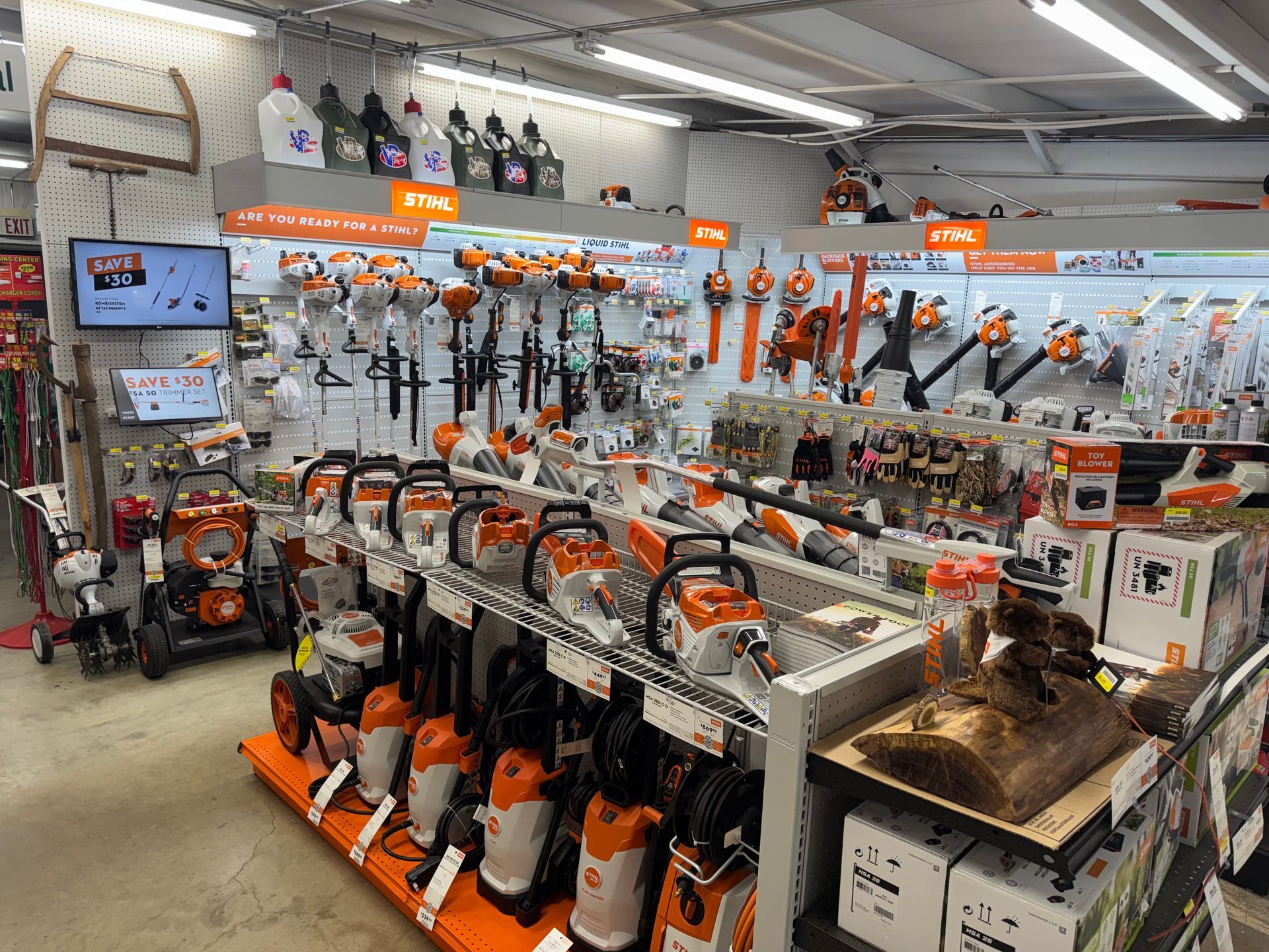 Inside a hardware store, STIHL chainsaws and power tools are displayed on shelves.