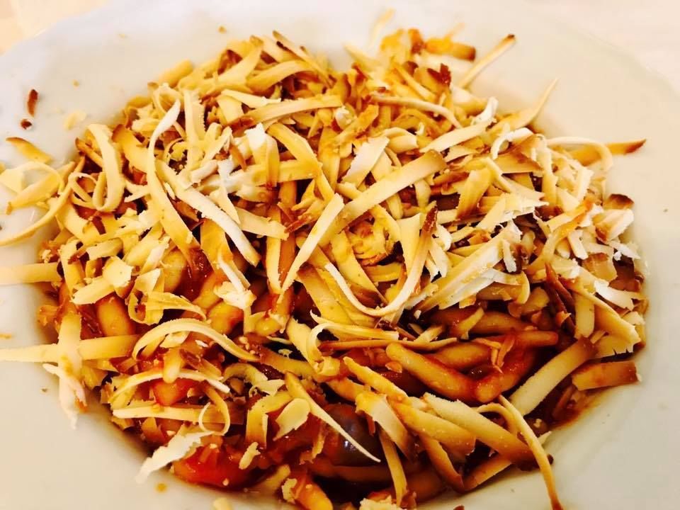 Piatto di cibo con una guarnizione dorata e sminuzzata.