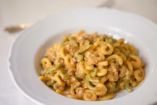 Piatto di pasta con salsa all'arancia in una ciotola bianca.