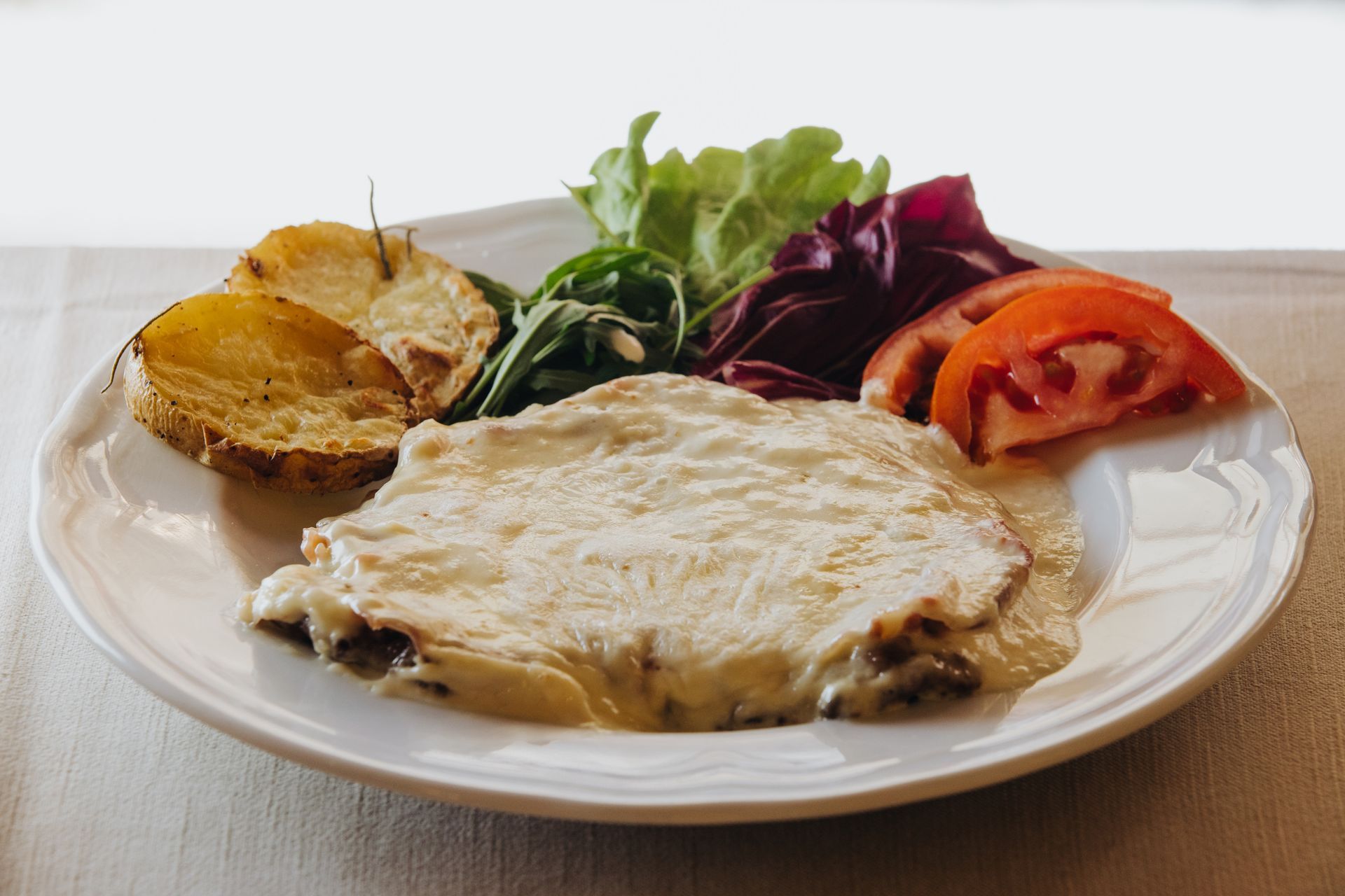 Piatto di pollo, patate e insalata.