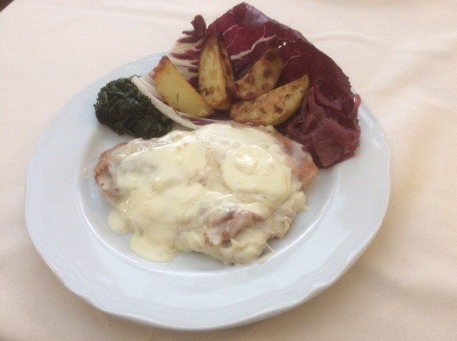 Piatto di cibo con pollo ricoperto di salsa, patate e insalata.