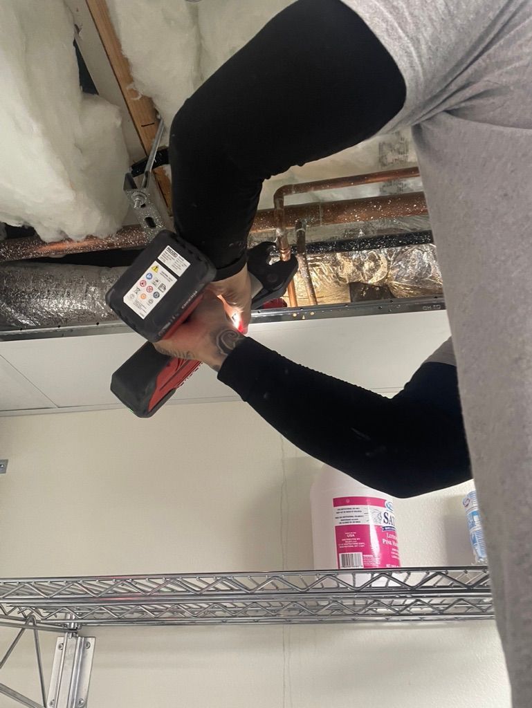 A person is working on a ceiling with a drill.