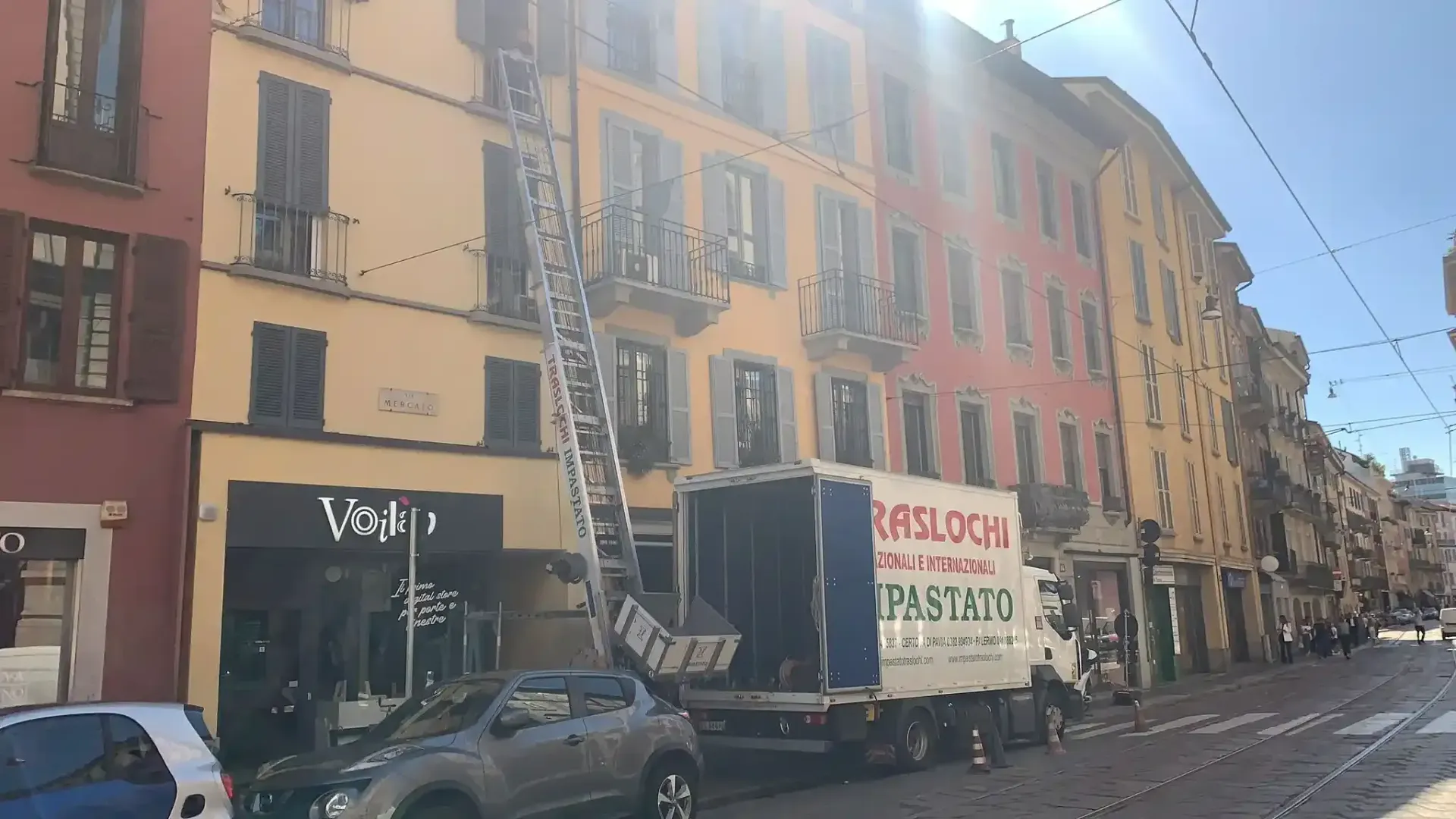 Autoscala Impastato Traslochi estesa davanti a palazzo milanese