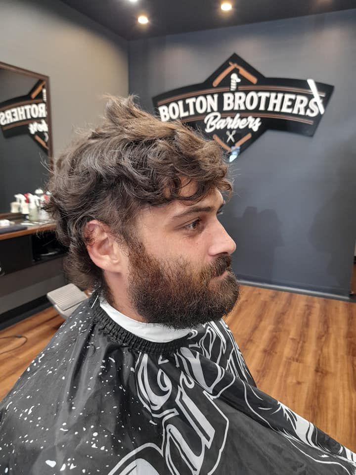 Man With Beard And Curly Hair In Barber Chair — Bolton Brothers Barbers in Erina, NSW
