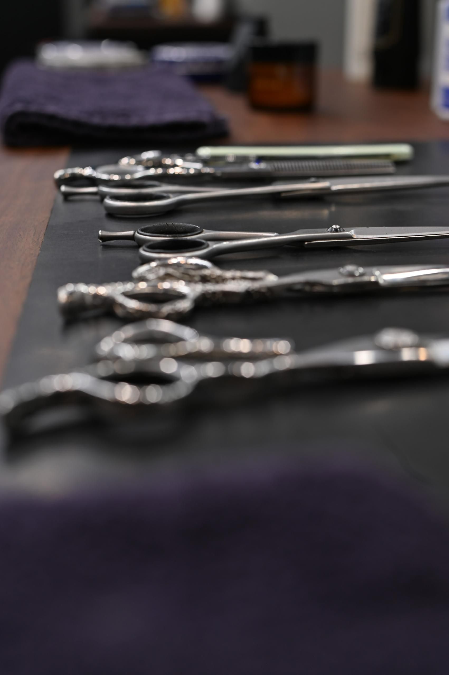 Scissors Lined Up On Black Mat — Bolton Brothers Barbers in Erina, NSW