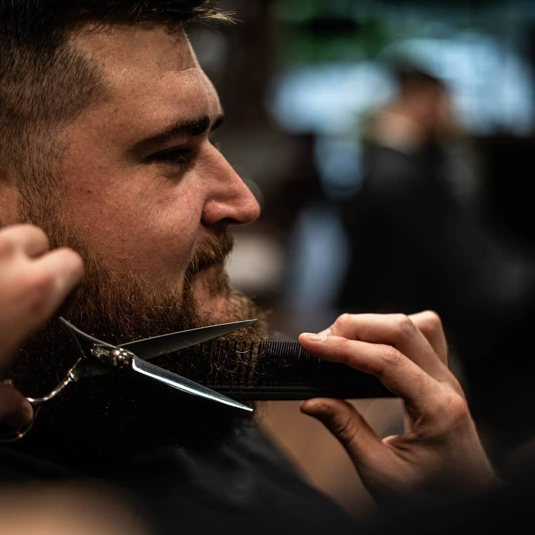 Barber Trimming Beard With Scissors And Comb — Bolton Brothers Barbers in Erina, NSW