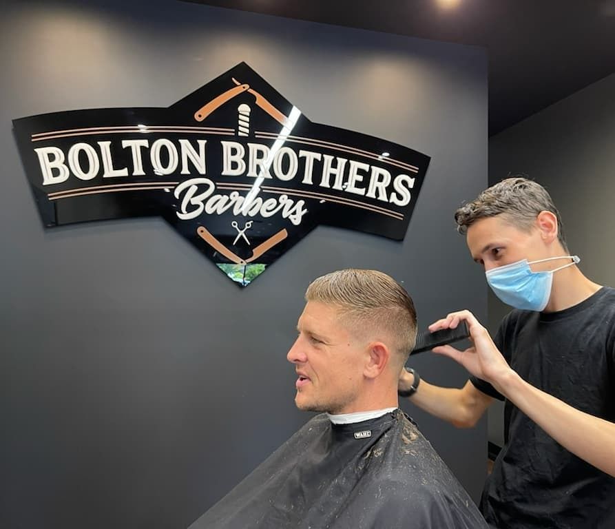 Barber Giving Haircut To Man In Mask — Bolton Brothers Barbers in Erina, NSW