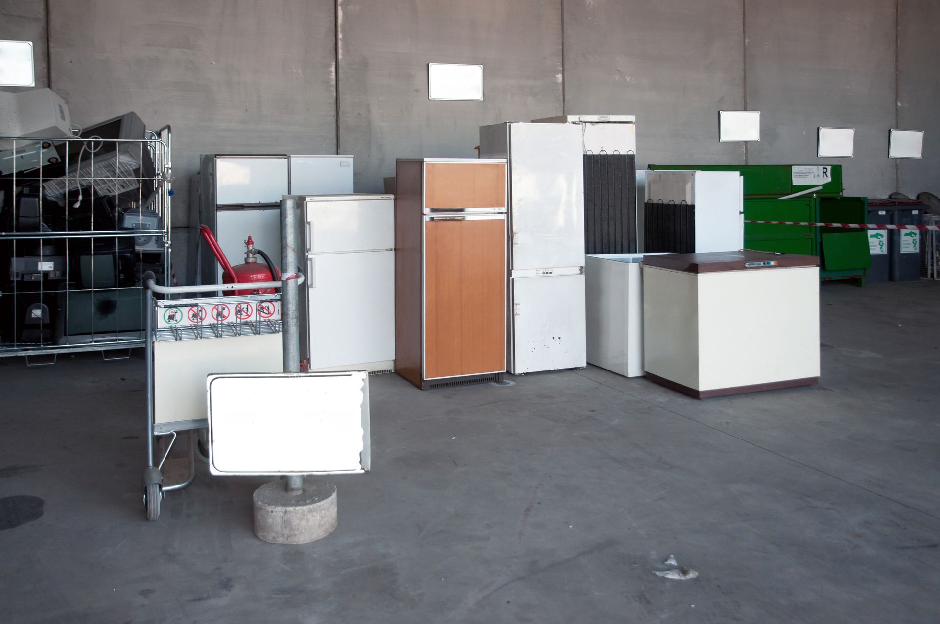 A spacious recycling warehouse filled with various models and sizes of refrigerators arranged neatly