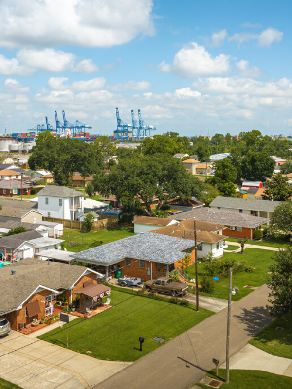 An aerial view of a residential neighborhood with a harbor in the background.