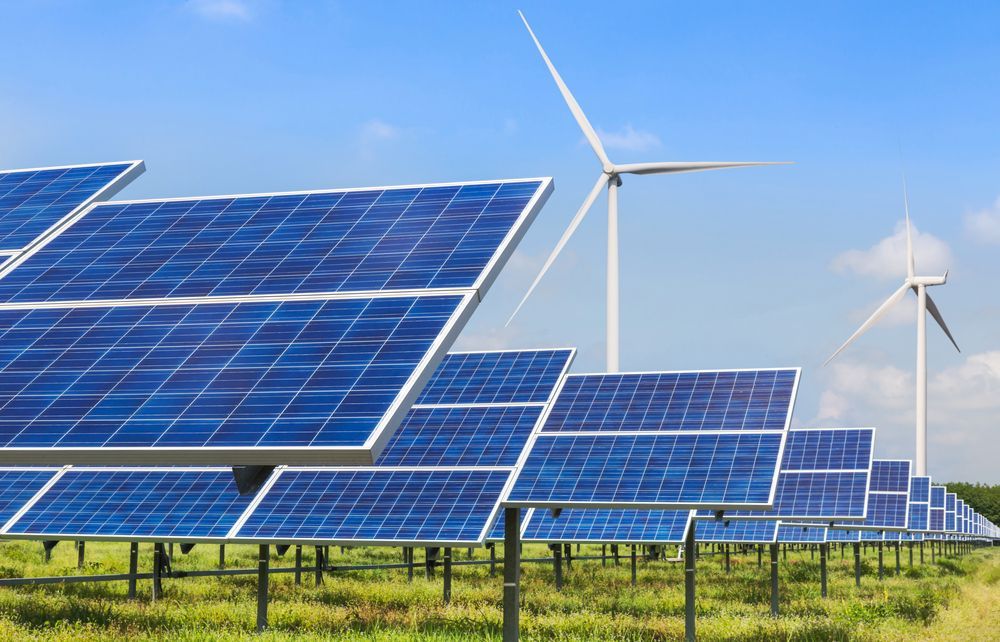 A Row Of Solar Panels And Wind Turbines In A Field — Trusted Energy Solutions In Nerang, QLD