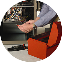 Person installing cables into an orange electronic device next to an open machine cabinet
