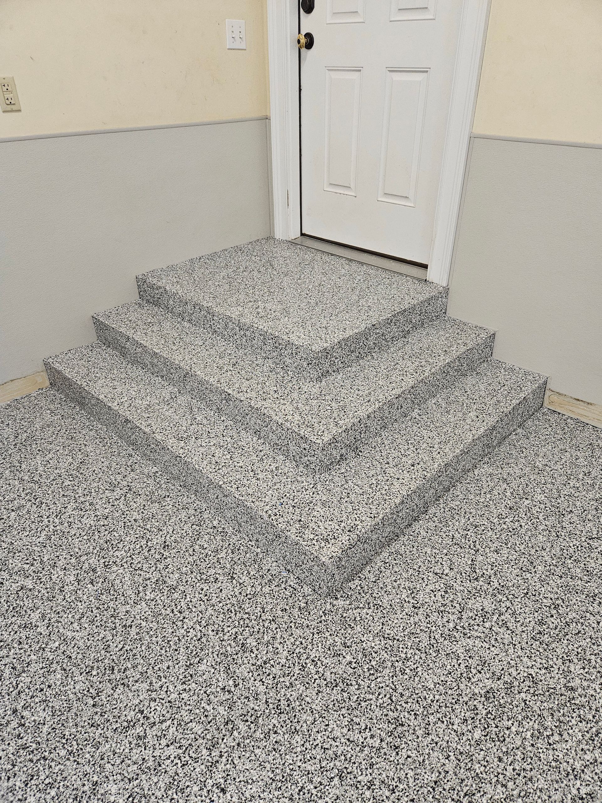 A gray concrete floor with white squares drawn on it.