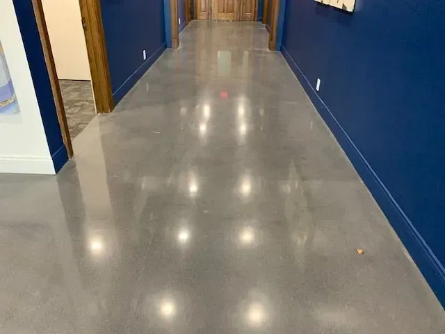 A hallway with a shiny concrete floor and blue walls.