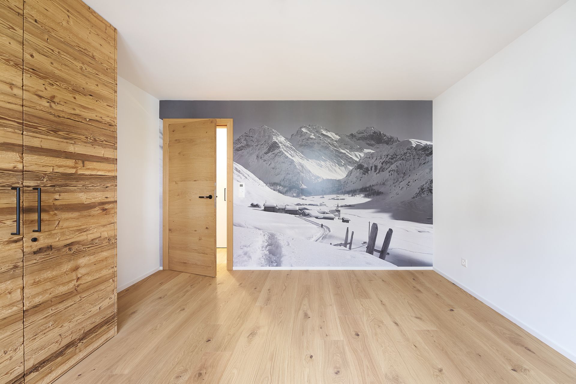 Ein leerer Raum mit einem Bild von Bergen an der Wand