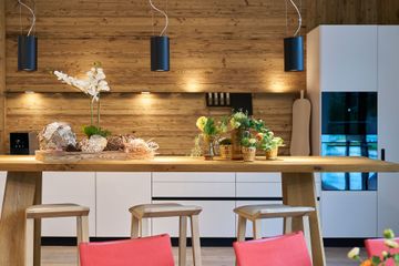 Eine Küche mit langem Holztisch und Hockern