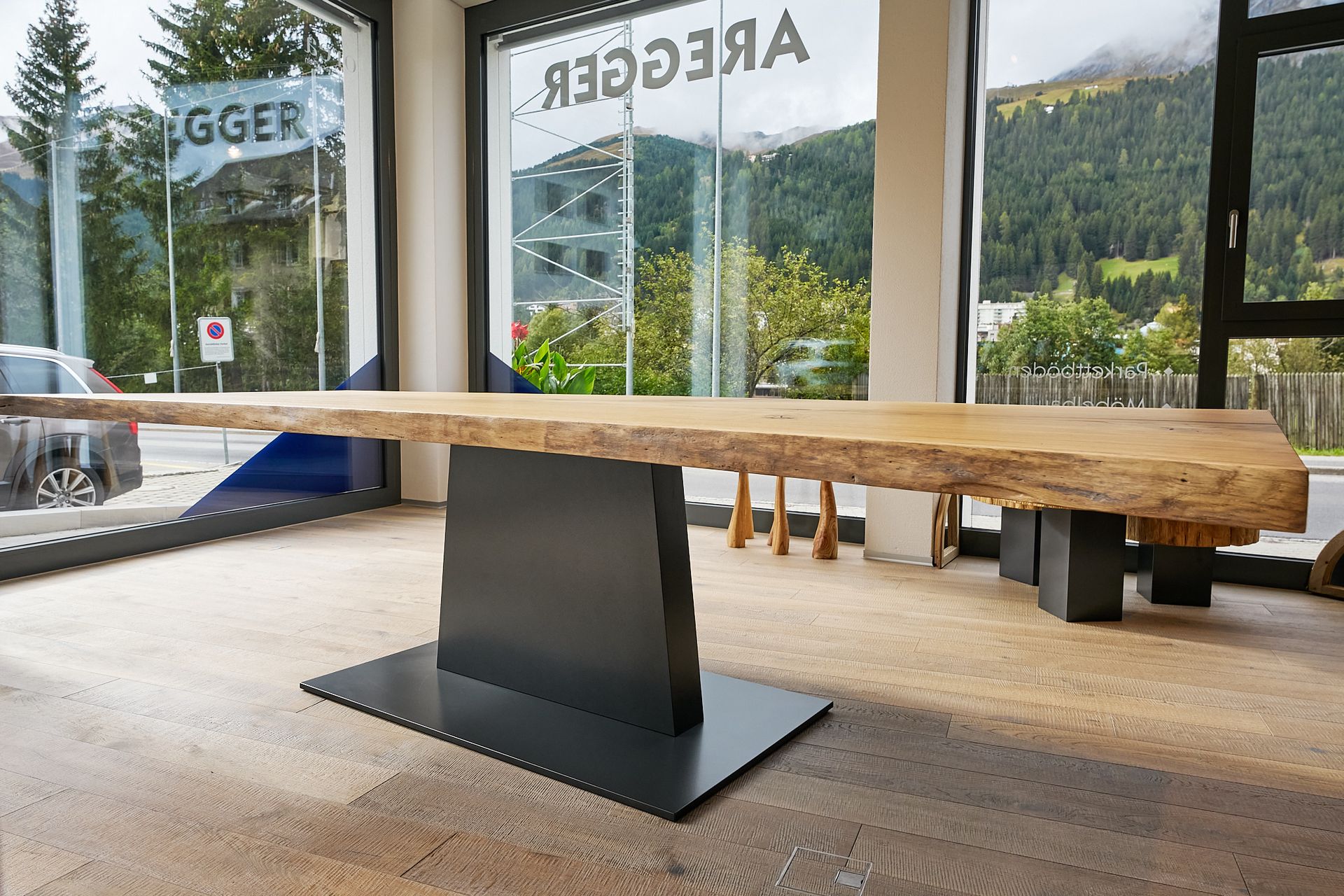Ein großer Holztisch steht vor einem Fenster mit einem Schild mit der Aufschrift 