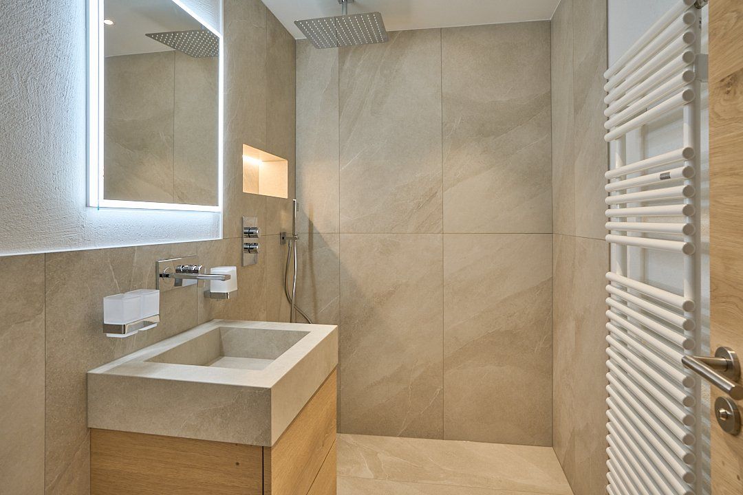 Ein Badezimmer mit Waschbecken, Spiegel und Handtuchhalter