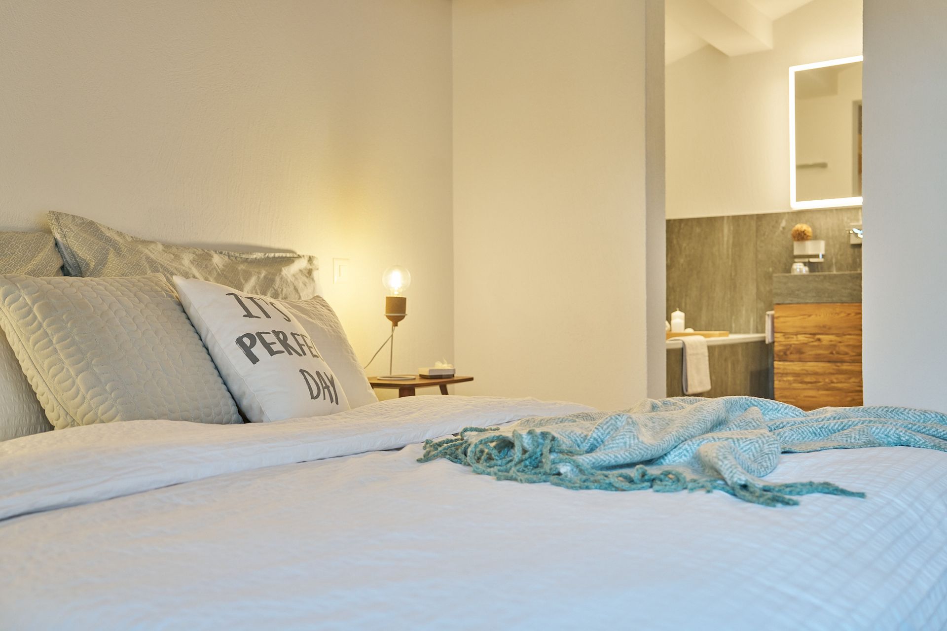 Ein Bett mit einem Kissen, auf dem steht: „Es ist ein schöner Tag“
