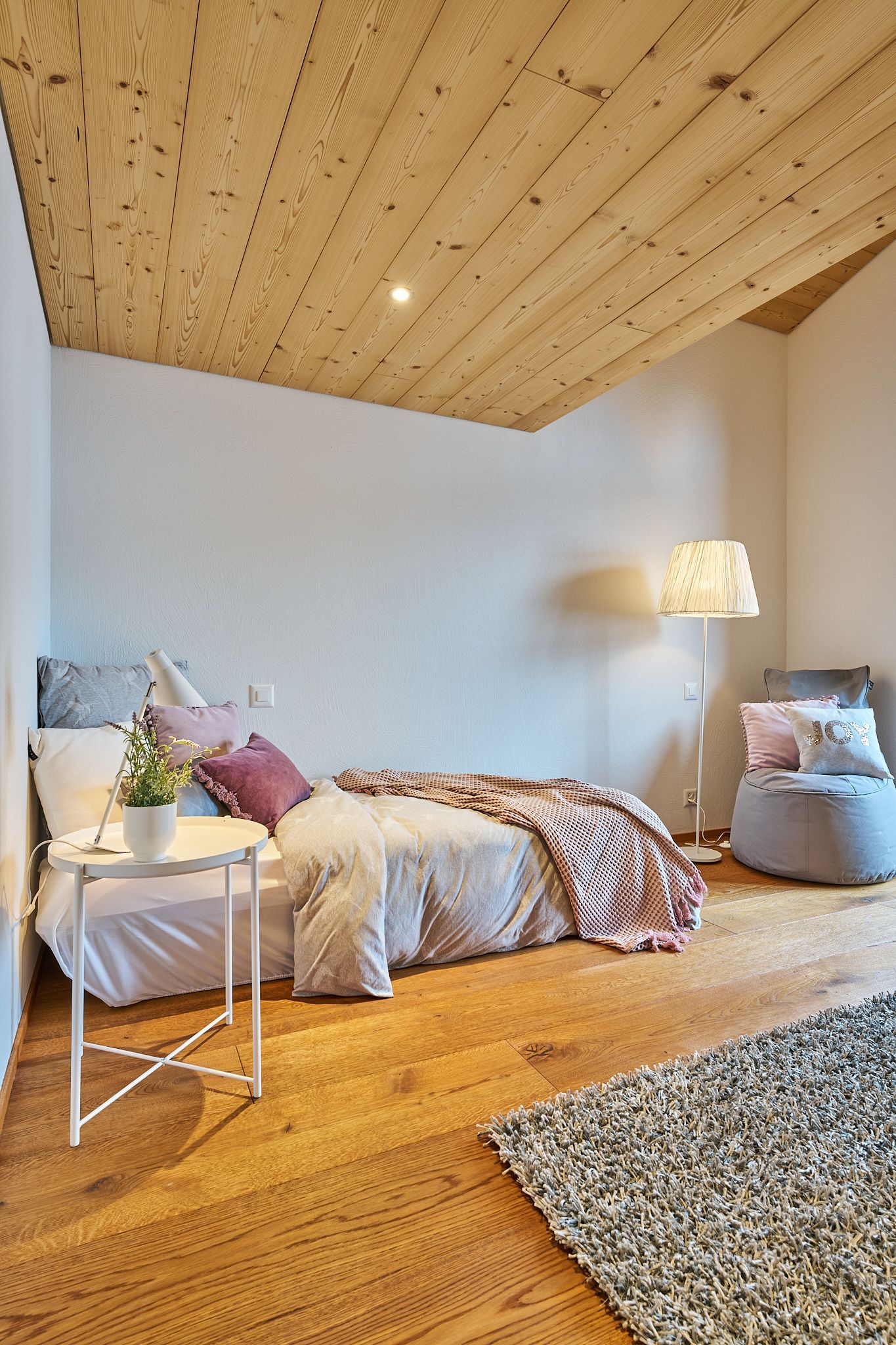 Ein Schlafzimmer mit Holzdecke und einem Bett