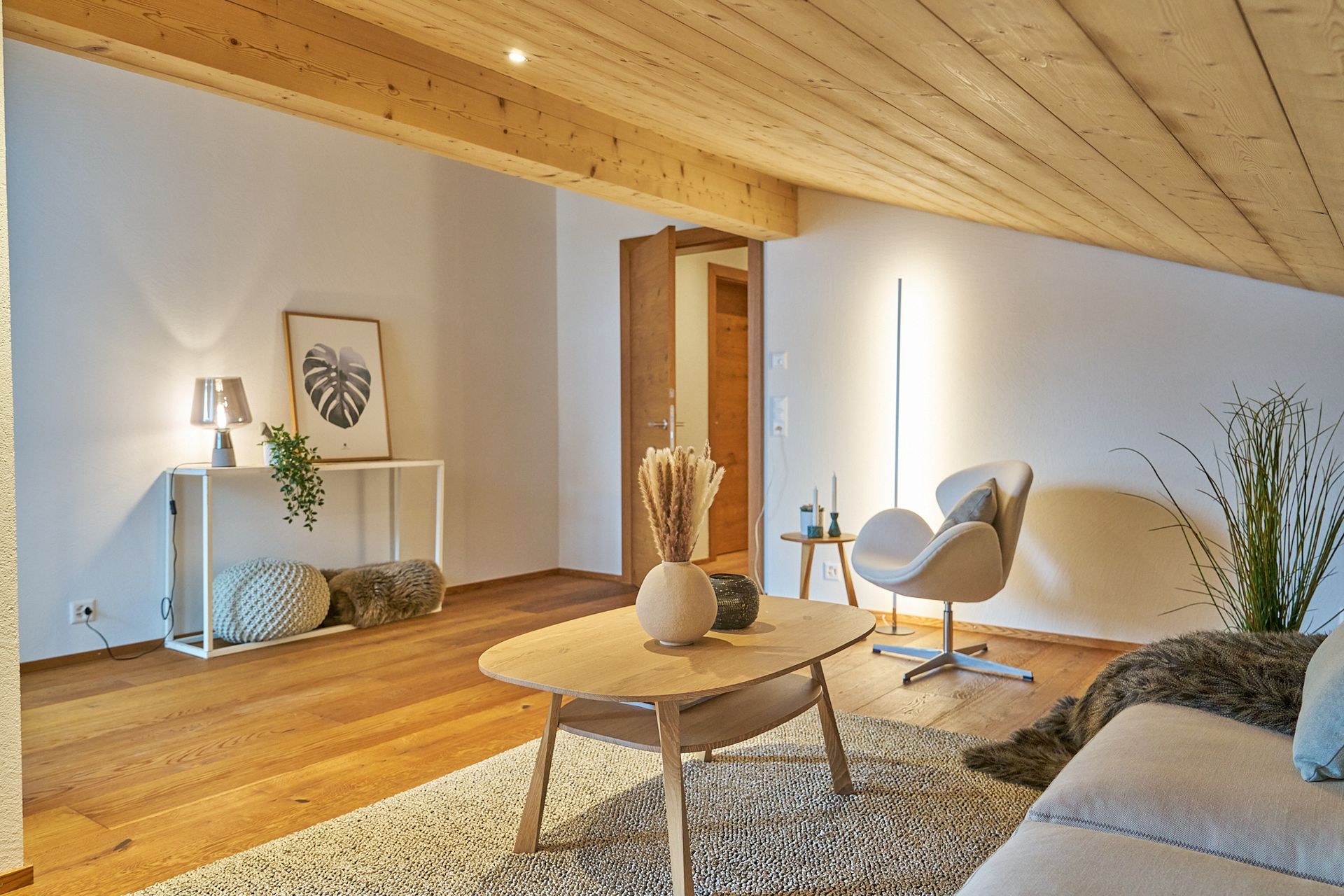 Ein Wohnzimmer mit Couch, Sessel, Couchtisch und Teppich.