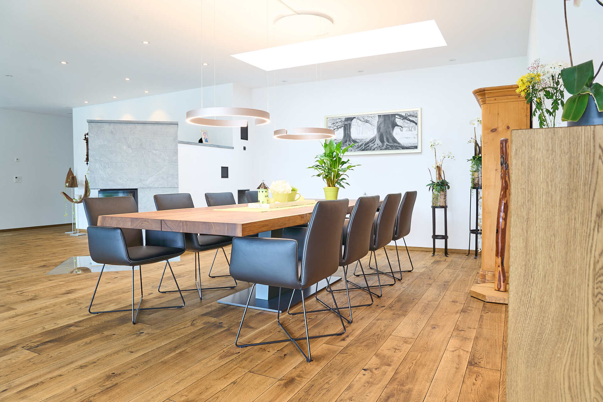 Ein Esszimmer mit einem langen Holztisch und Stühlen.