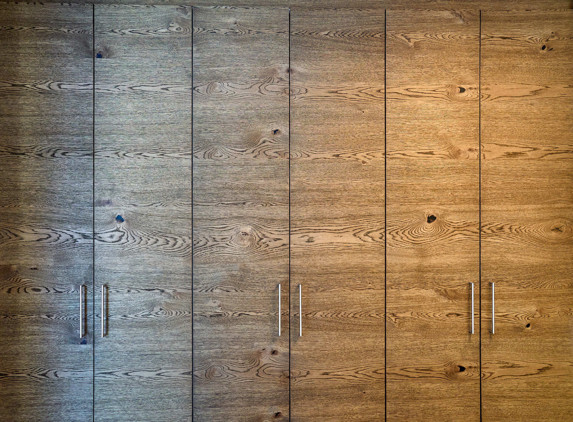 Eine Nahaufnahme einer Holzwand mit einer Reihe Holztüren.