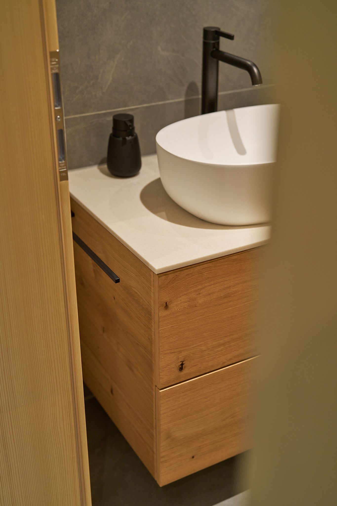 Ein Badezimmer mit einem Holzwaschtisch und einem weißen Waschbecken