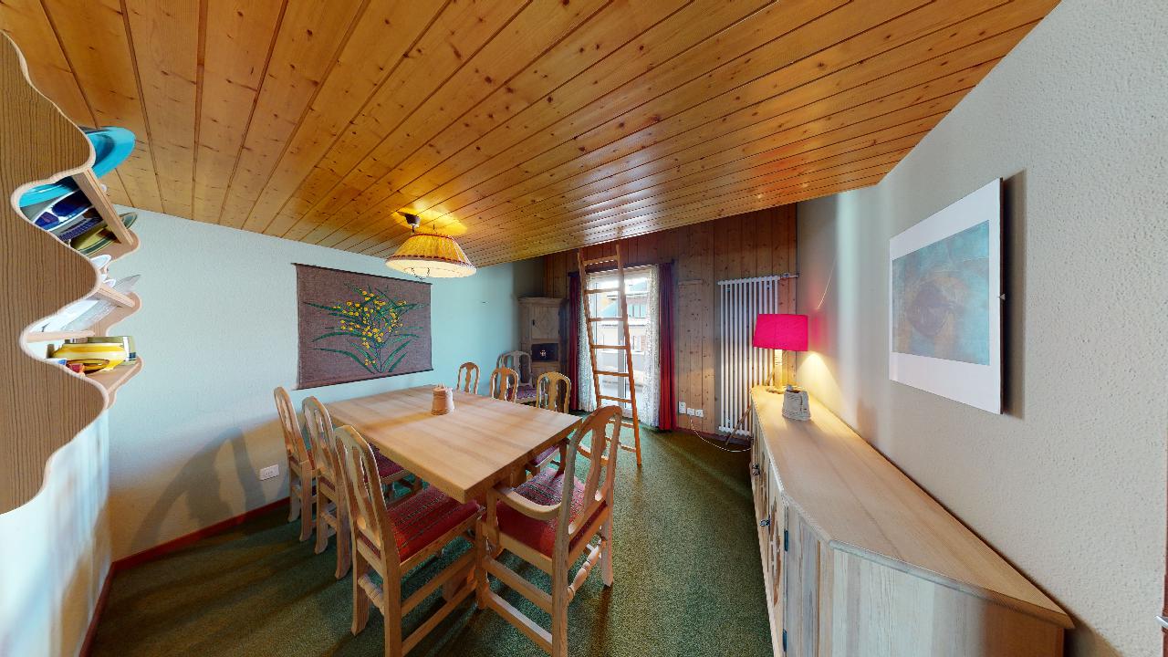 Ein Esszimmer mit einem Holztisch und Stühlen