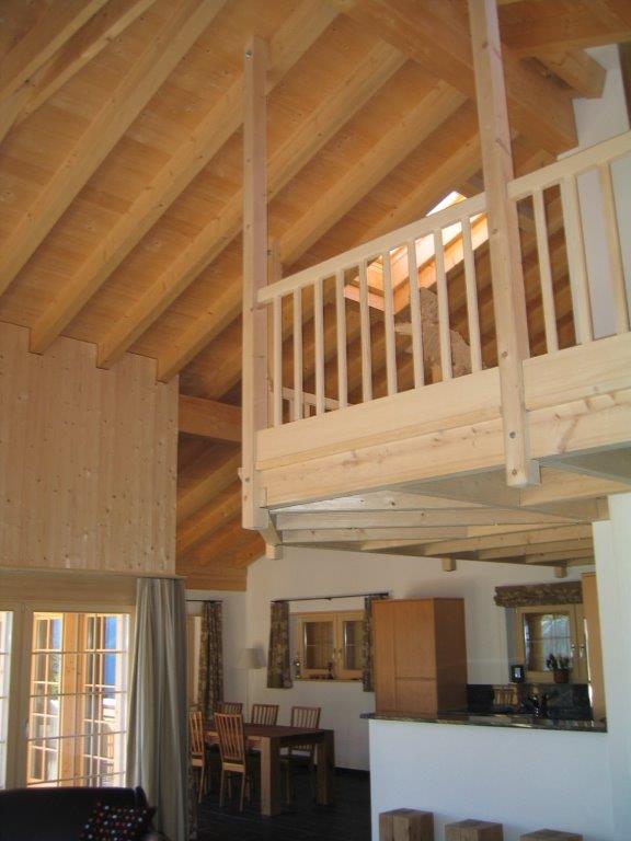 Ein Wohnzimmer mit Holzgeländer und Balkon