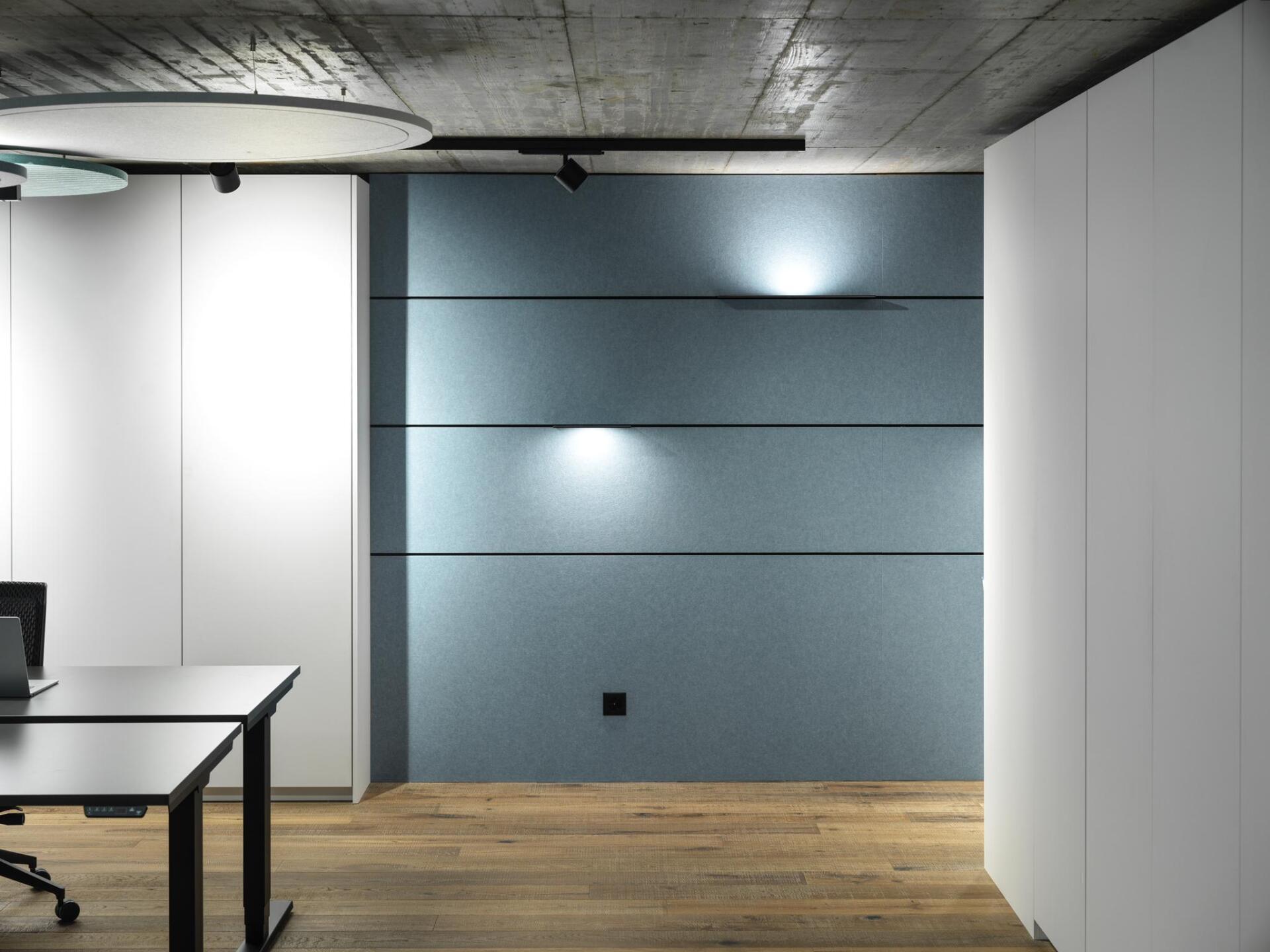 Ein Raum mit zwei Schreibtischen und einer blauen Wand