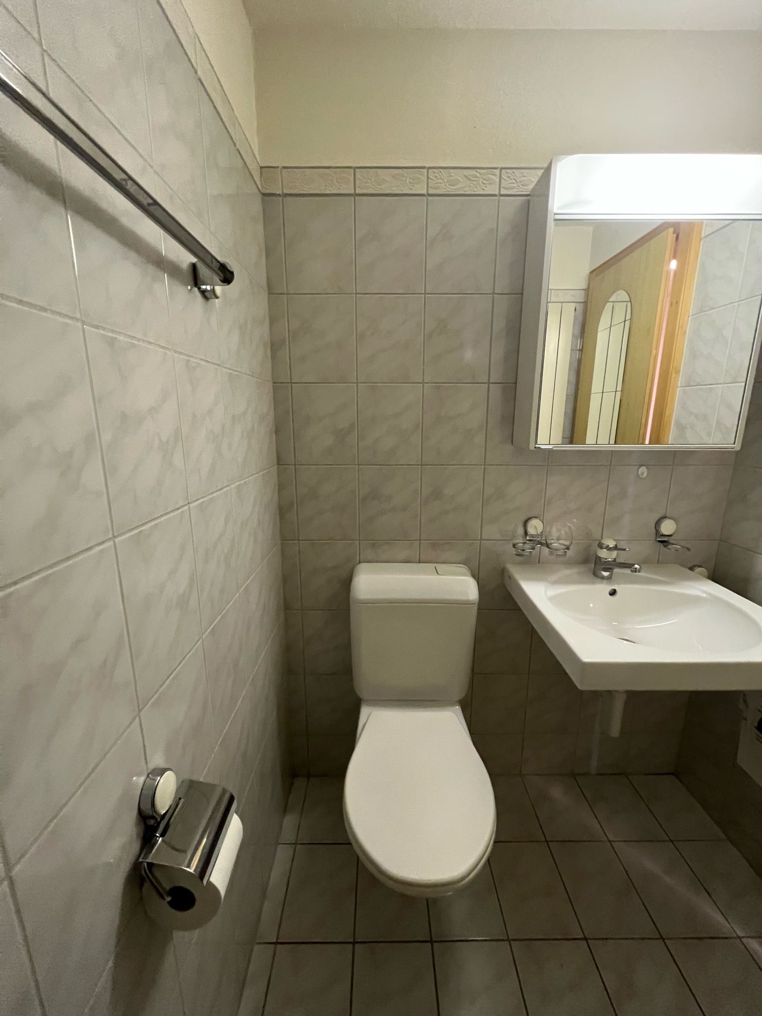 Ein Badezimmer mit Toilette, Waschbecken und Spiegel.