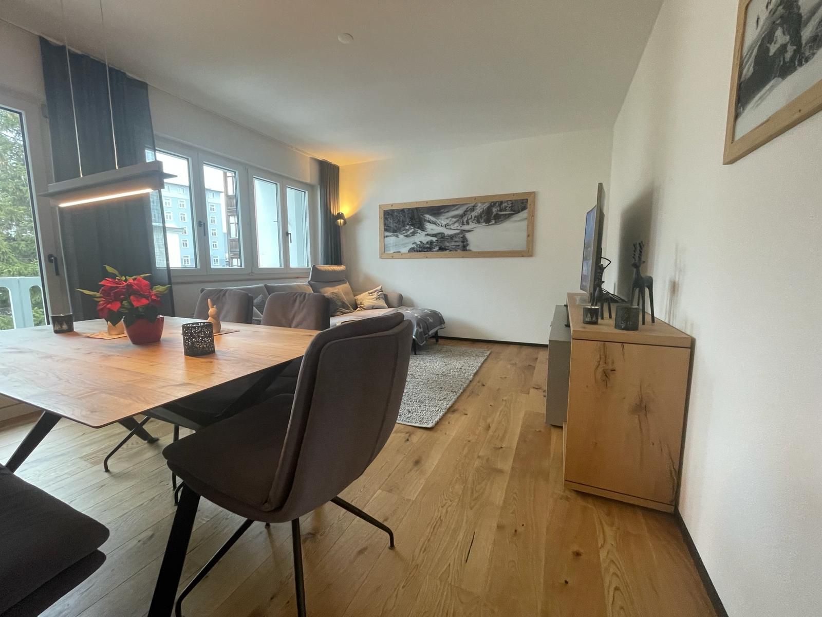 Ein Wohnzimmer mit Tisch und Stühlen und einem Fernseher.