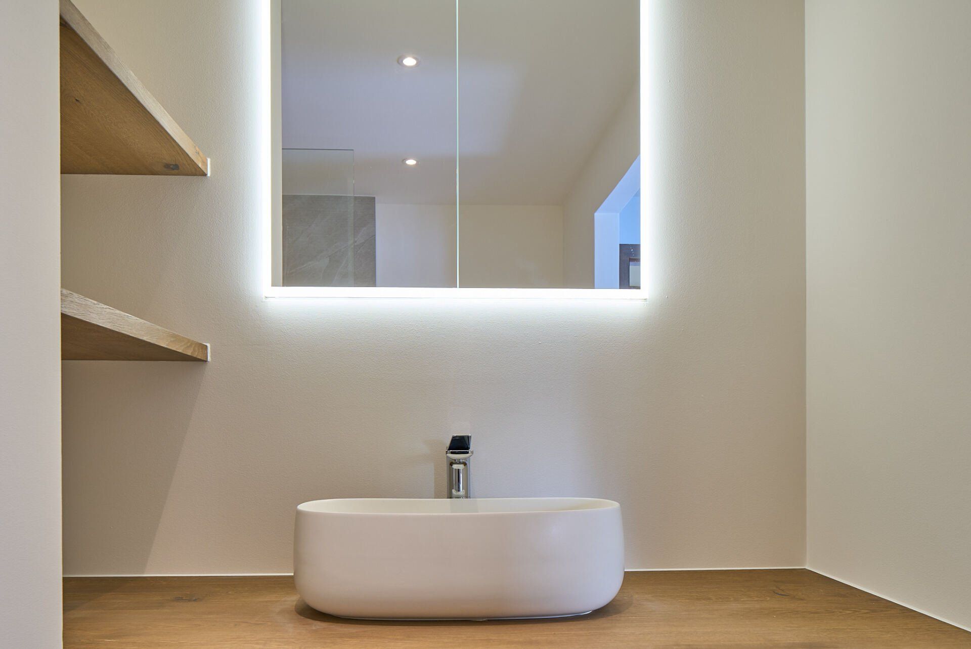 Ein Badezimmer mit Waschbecken und Spiegel an der Wand.