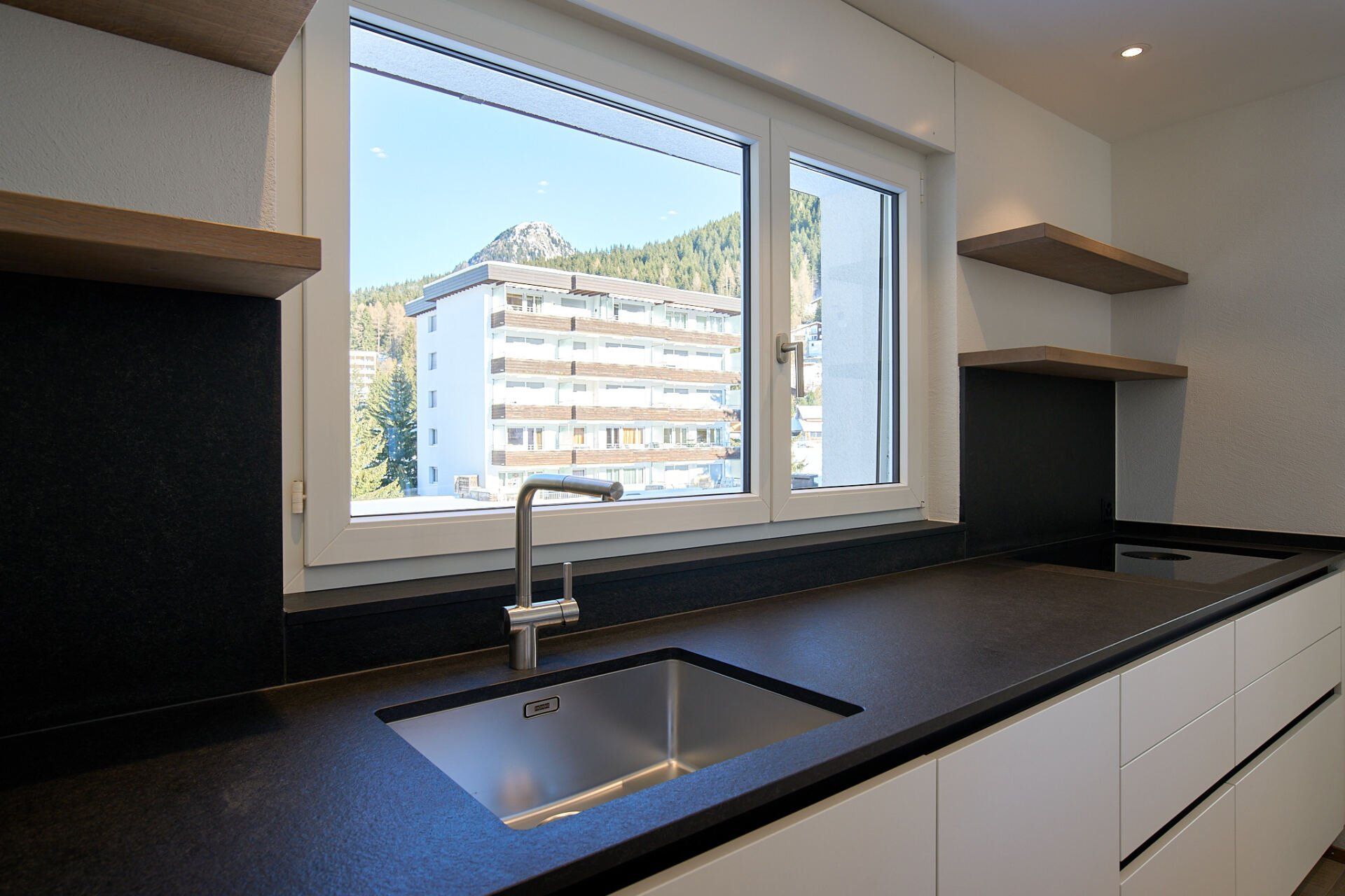 Eine Küche mit Spüle und Fenster mit Blick auf die Stadt