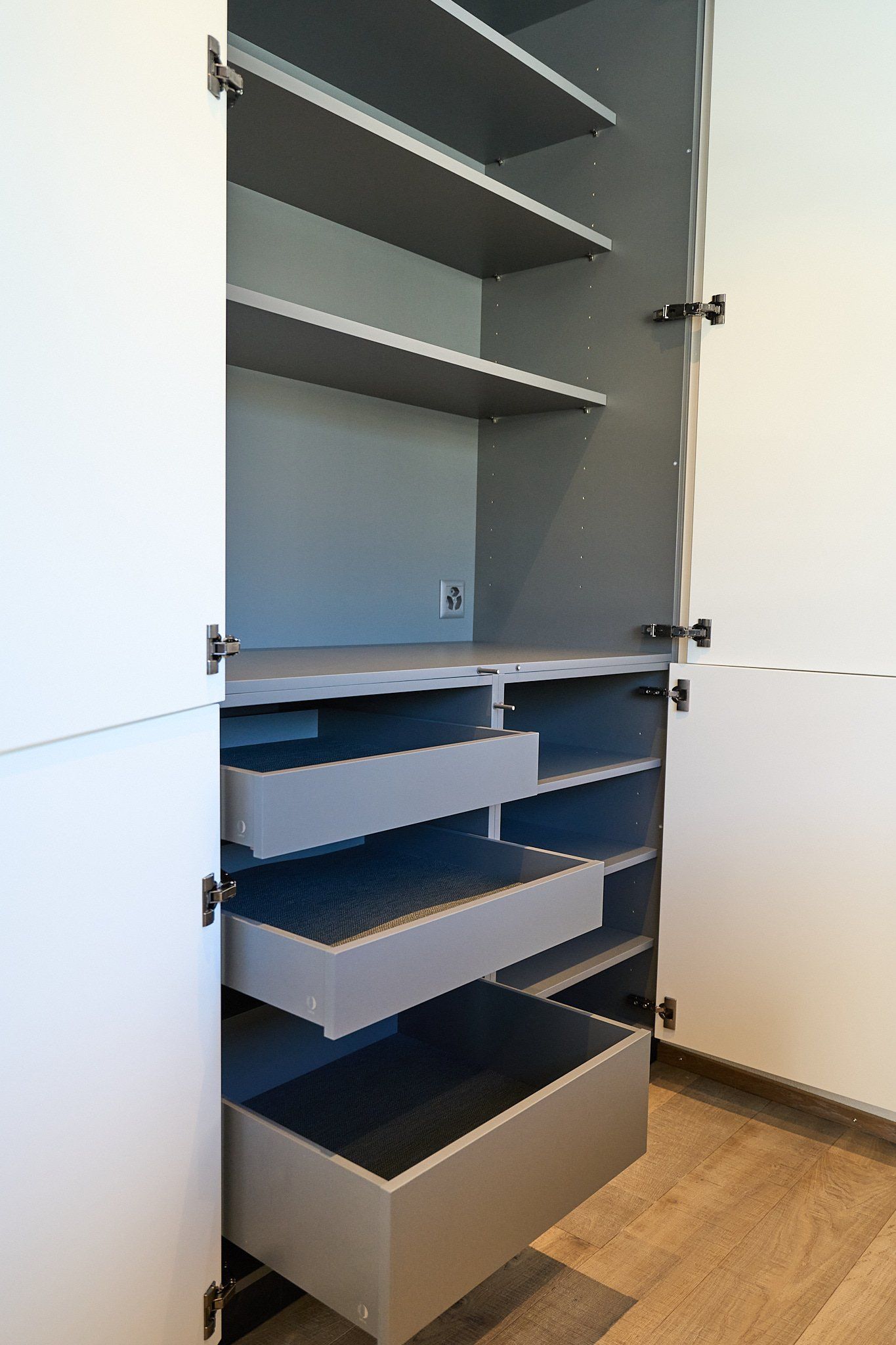 Ein Schrank mit einer offenen Schublade und Regalen.