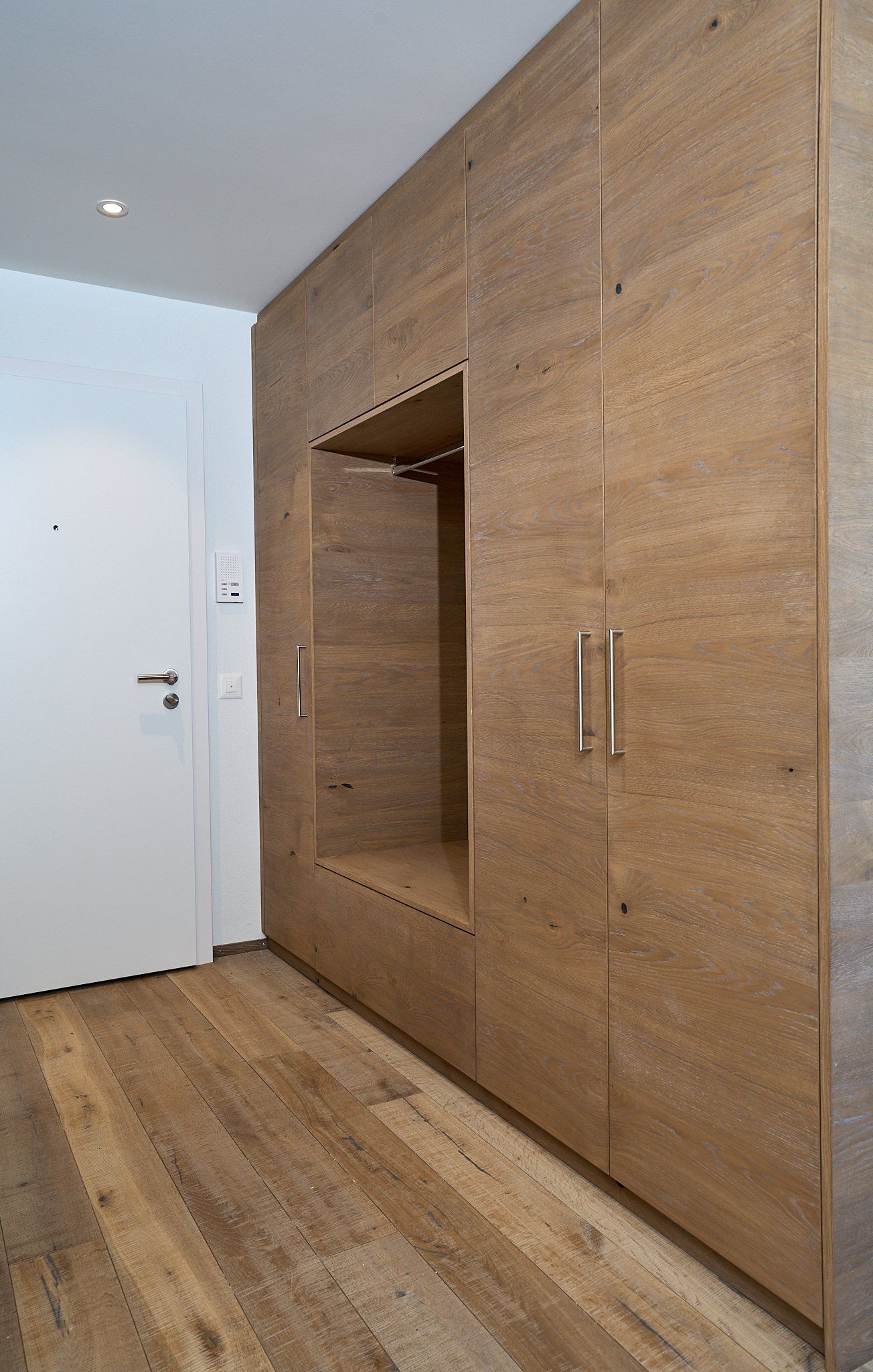 Ein Flur mit Holzschränken und einer weißen Tür.