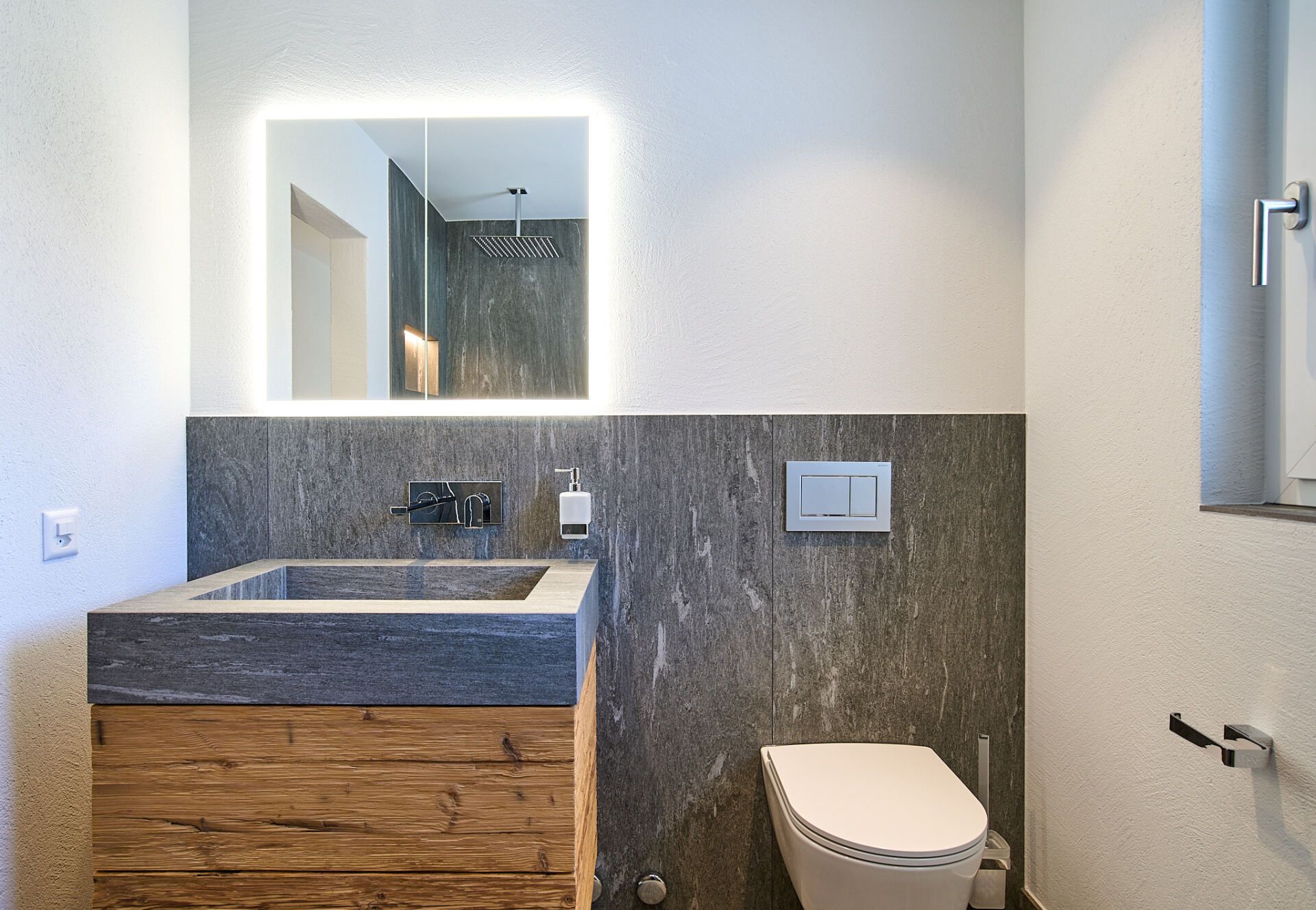 Ein Badezimmer mit Waschbecken, Toilette, Spiegel und Fenster.