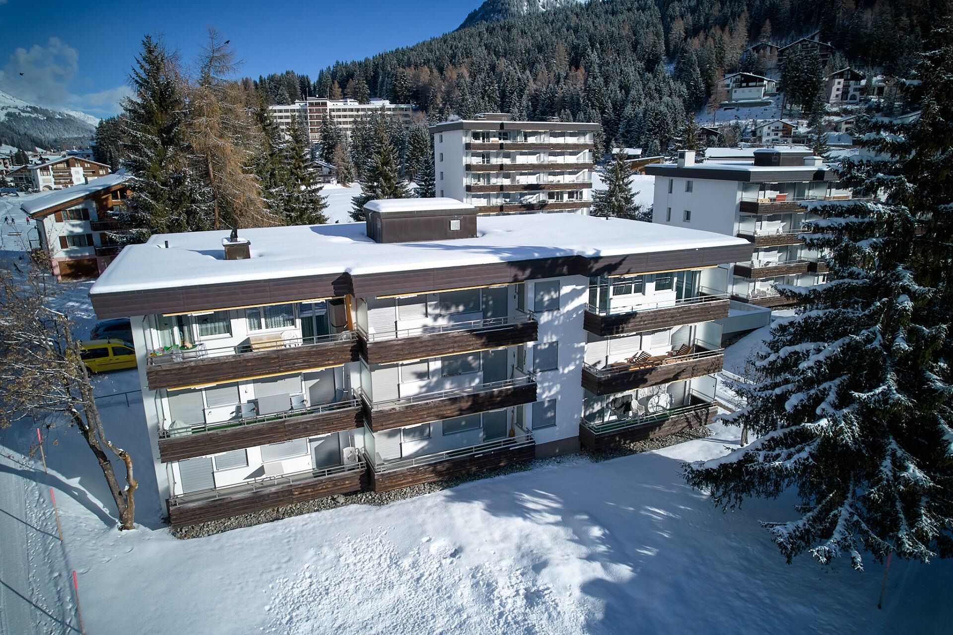 Eine Luftaufnahme eines schneebedeckten Gebäudes in den Bergen.
