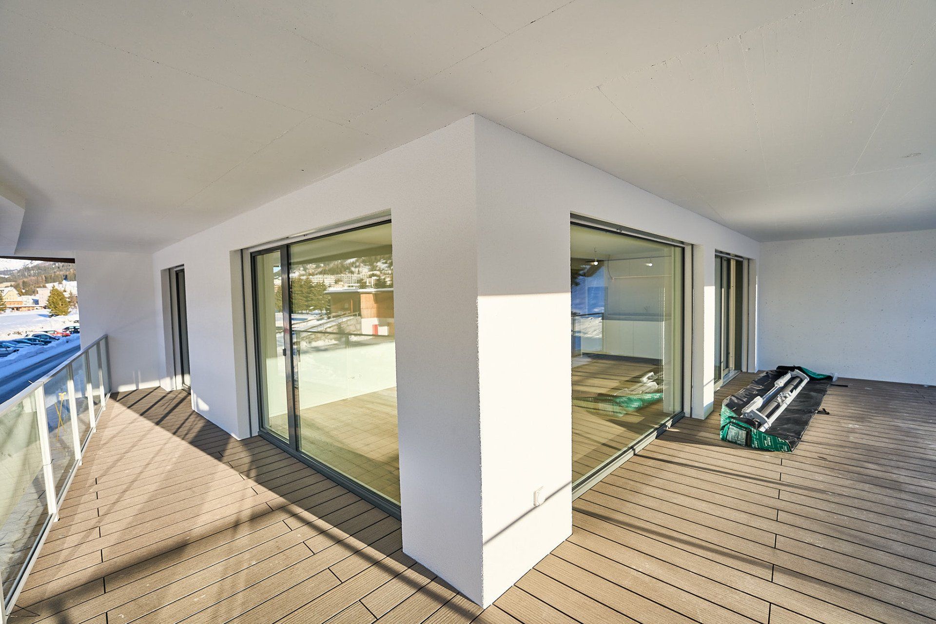Ein Balkon mit vielen Fenstern und einem Holzboden