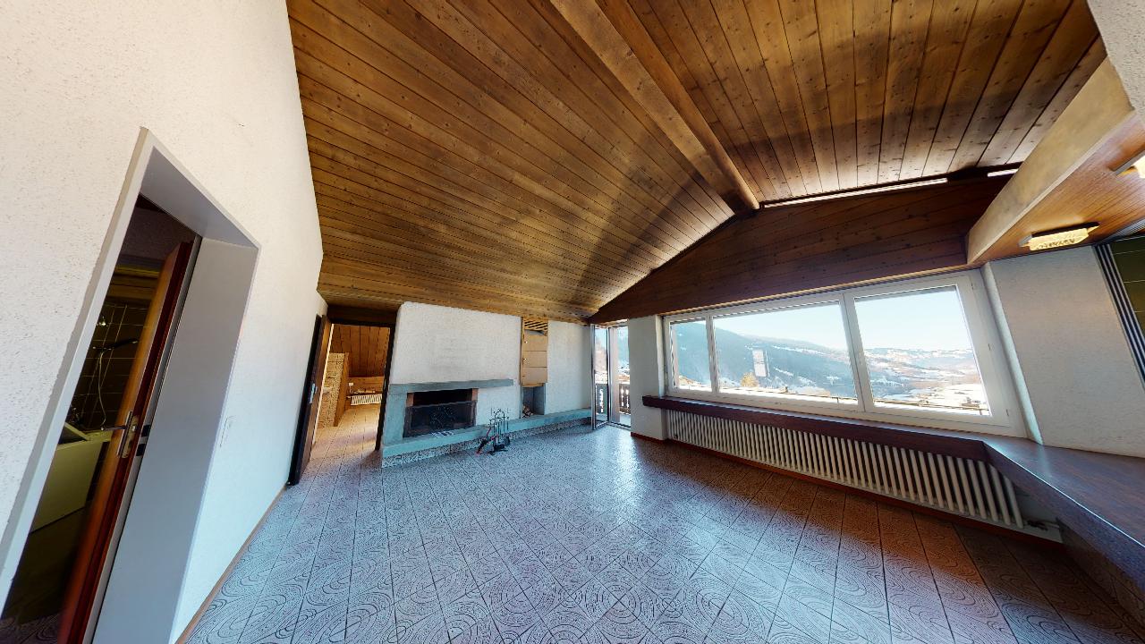 Ein Wohnzimmer mit Kamin und vielen Fenstern