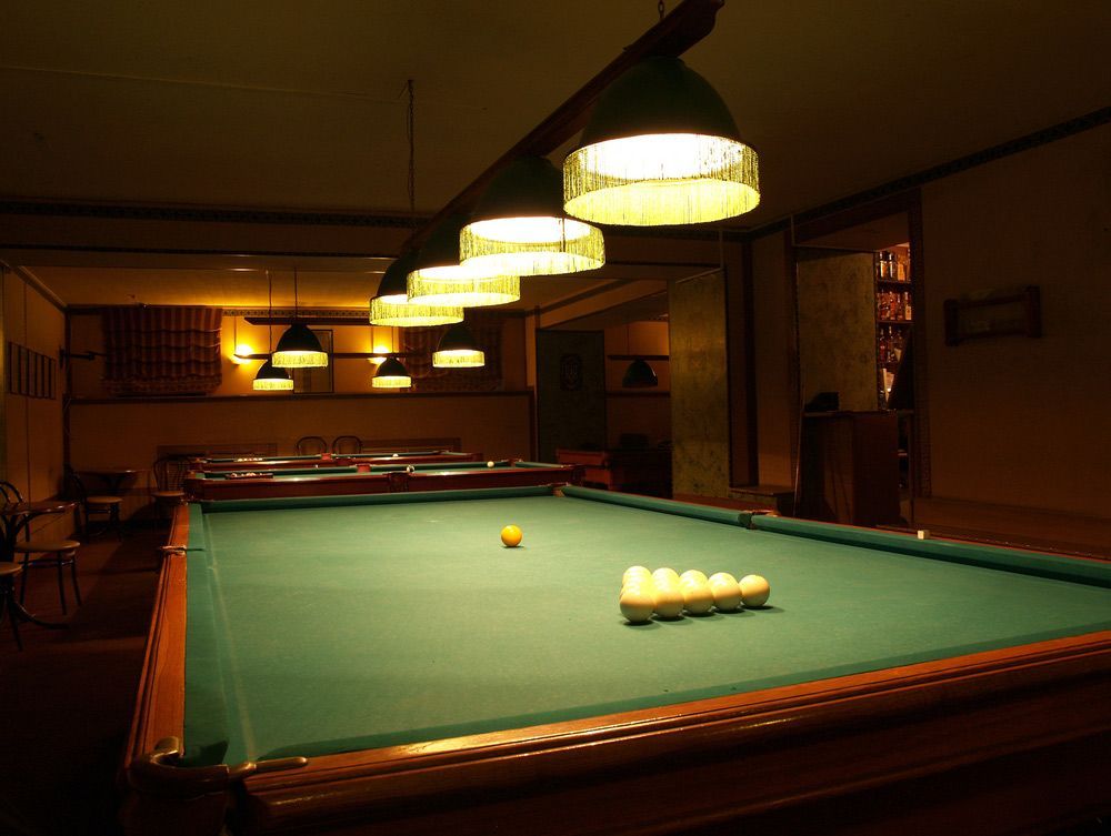 A Pool Table in a Dark Room With Lights Hanging From the Ceiling — Ocean Grove Removals In Ballarat, VIC